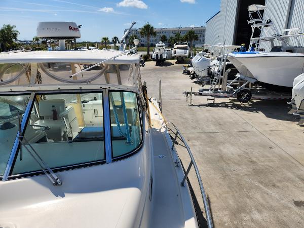 2005 Pursuit 3070 Offshore Center Console boat in a marina with other vessels.