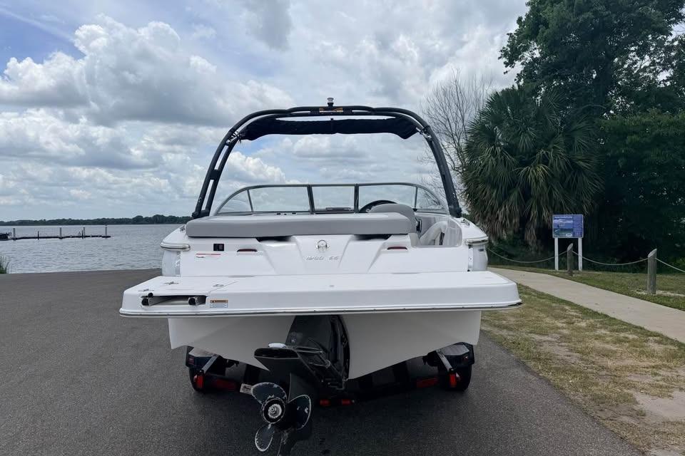 2019 Regal 1900 ES Bowrider boat on trailer by a lake, cloudy sky.