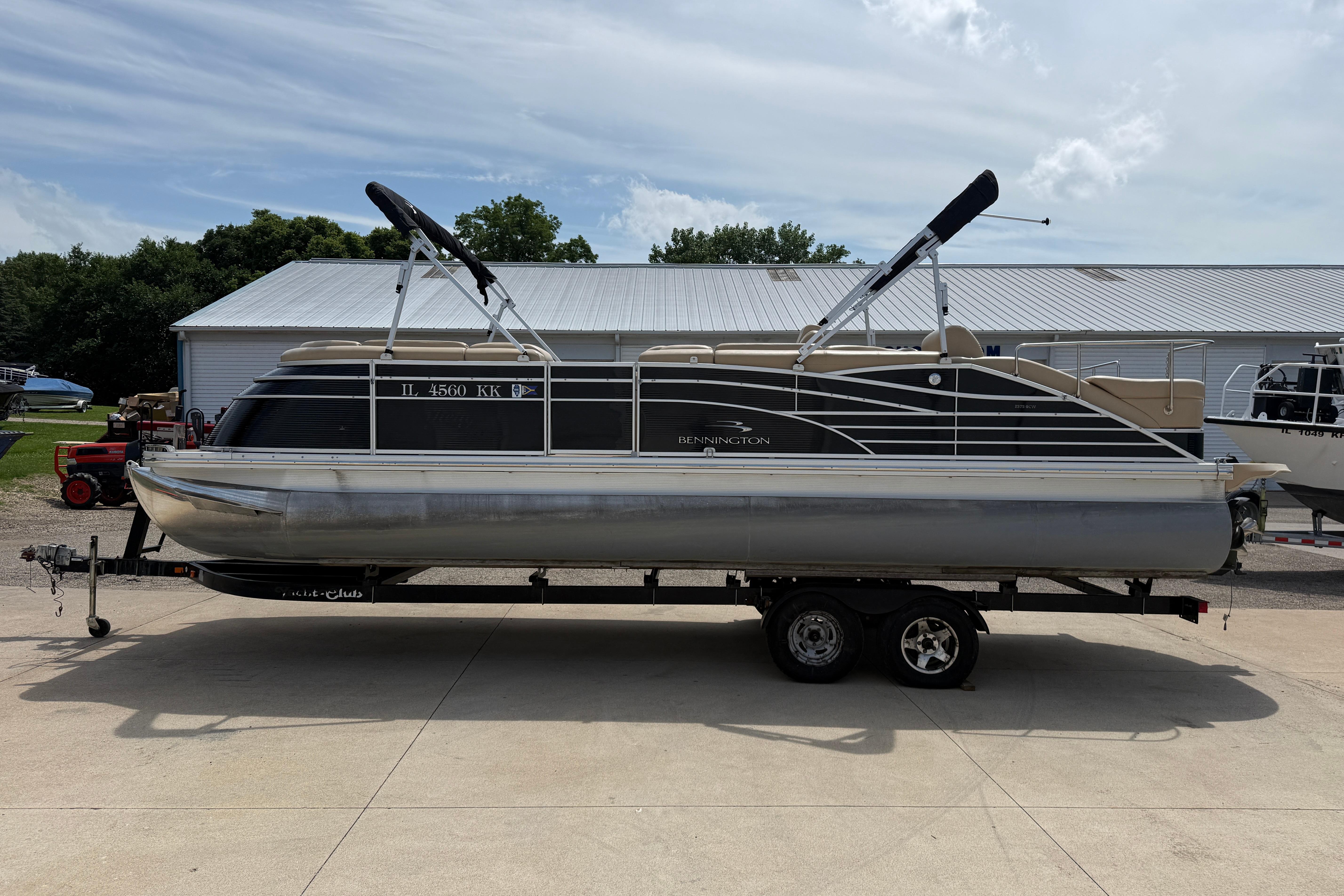 2011 Bennington 2575QCW I/O pontoon boat on trailer, parked outdoors.