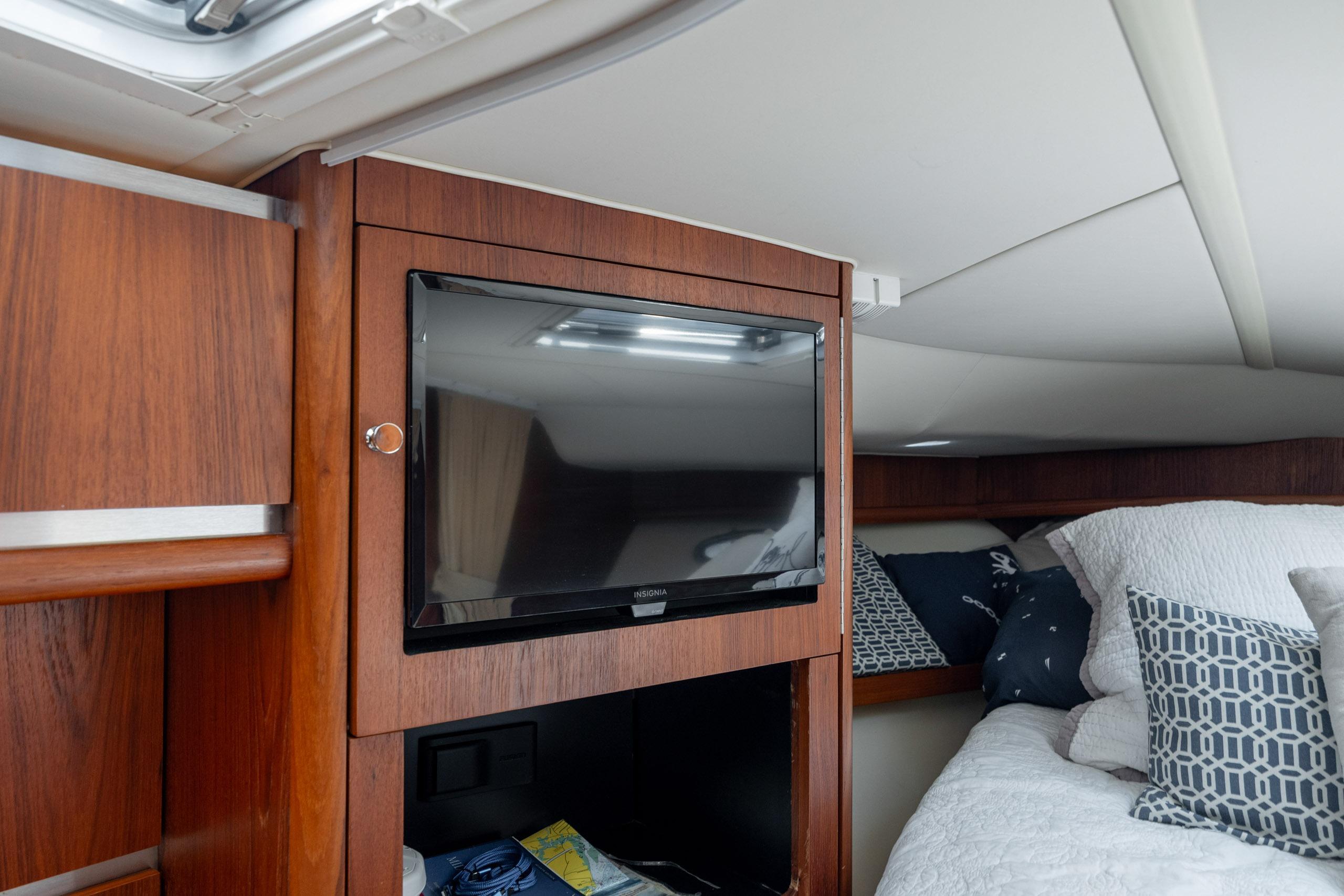 Interior of 2004 Tiara Yachts 3200 Open with TV and cozy bedding.