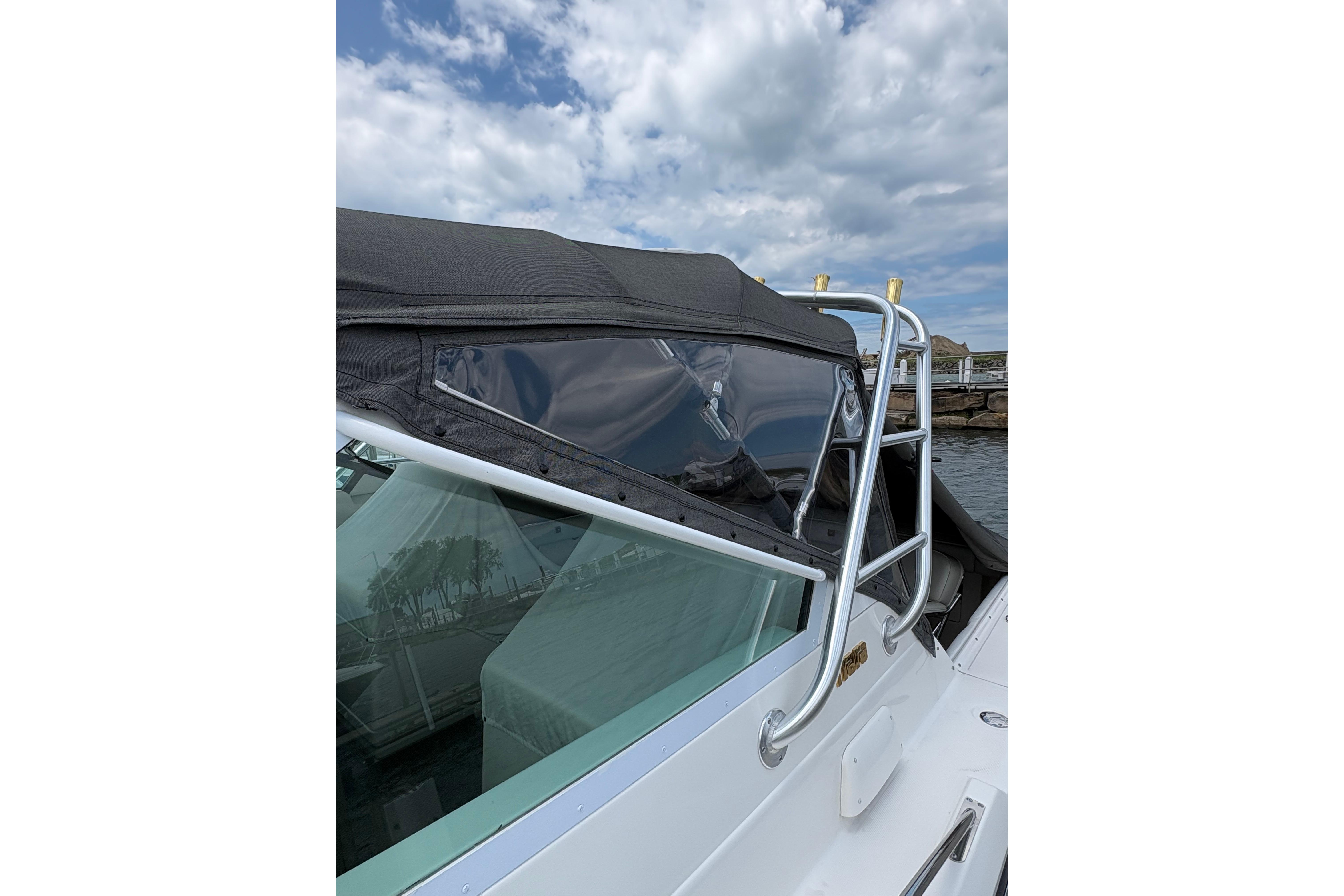 1999 Tiara Yachts 3100 Open boat with black canopy and stainless steel railing.