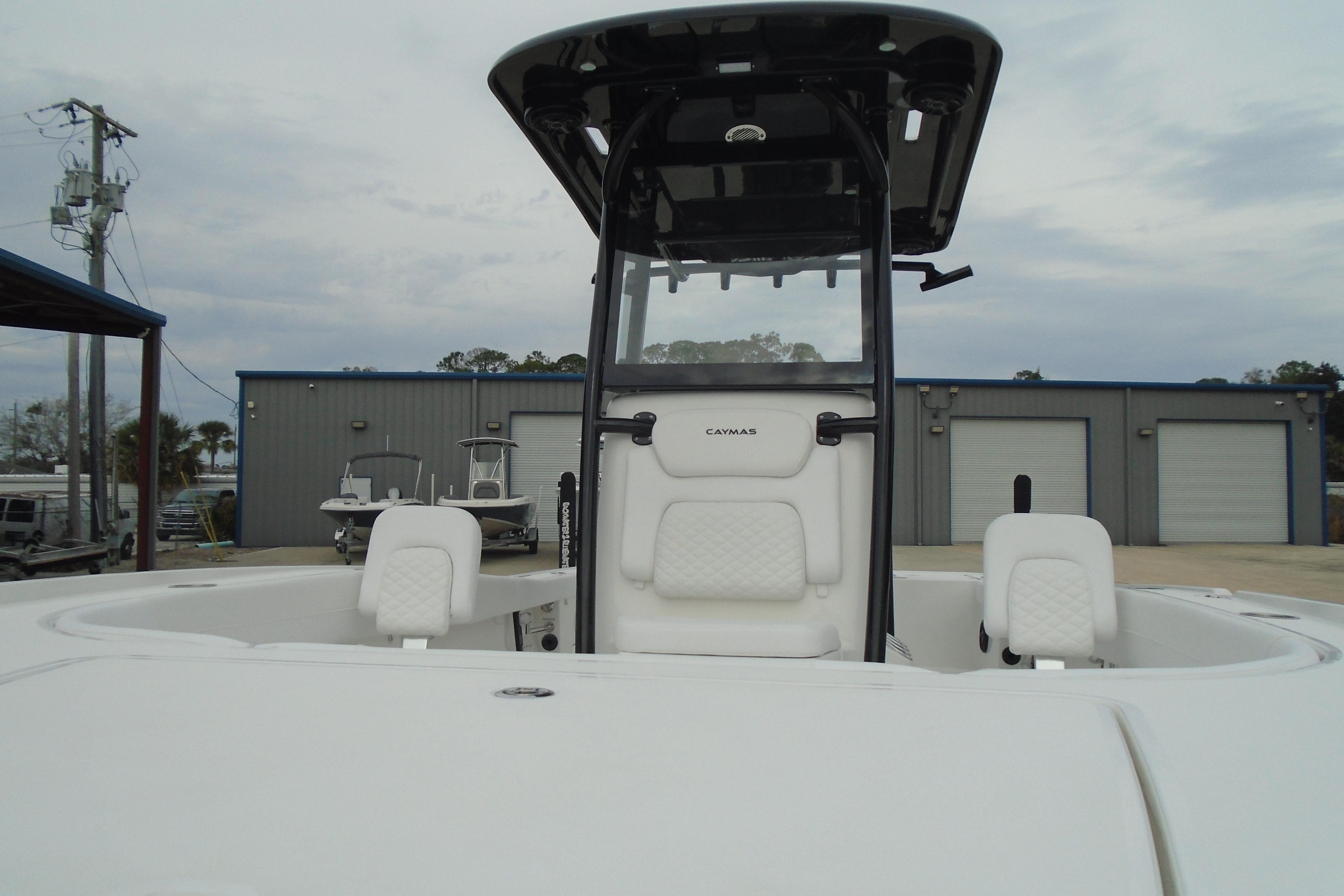 2026 Caymas 26 HB boat with white seating and T-top in a marina setting.