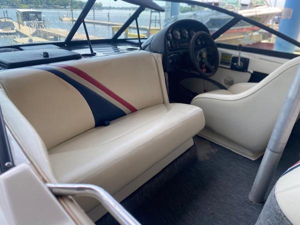1998 Malibu Response boat interior with white seating and dashboard, docked by the water.