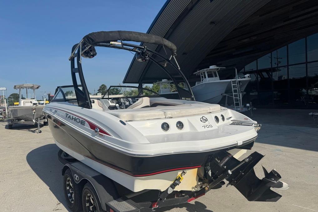 2018 Tahoe 700 TF boat on trailer, parked outdoors near a building.