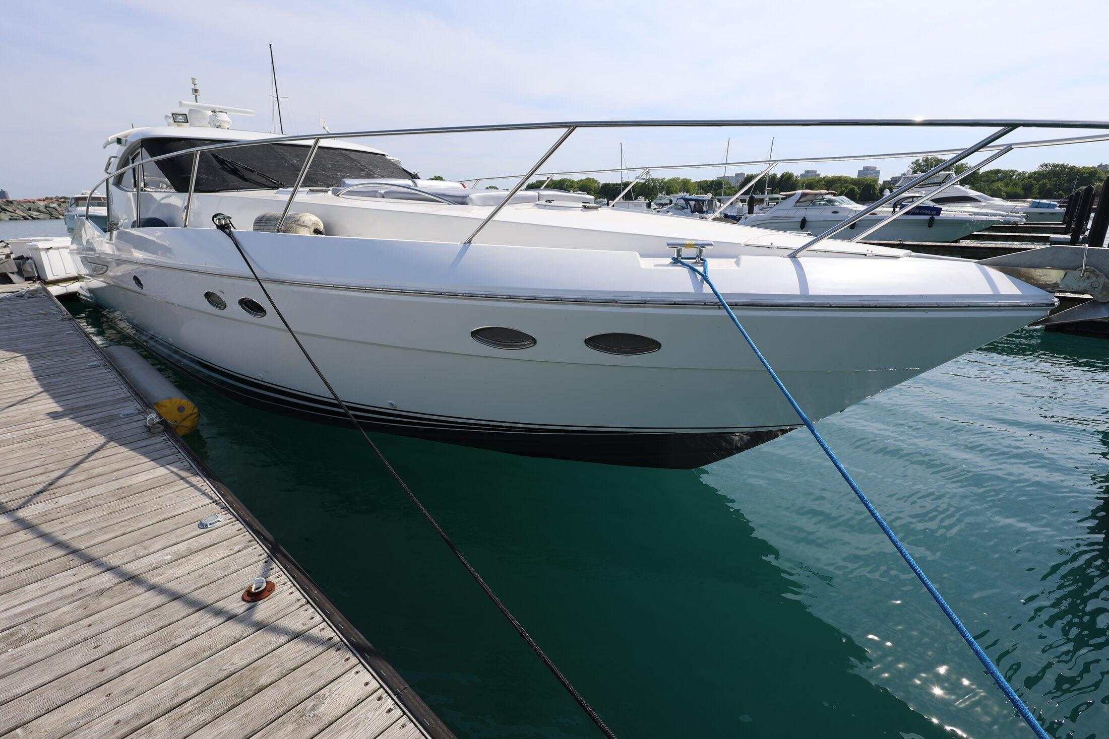 1999 Neptunus 54 Express yacht docked at marina, side view.
