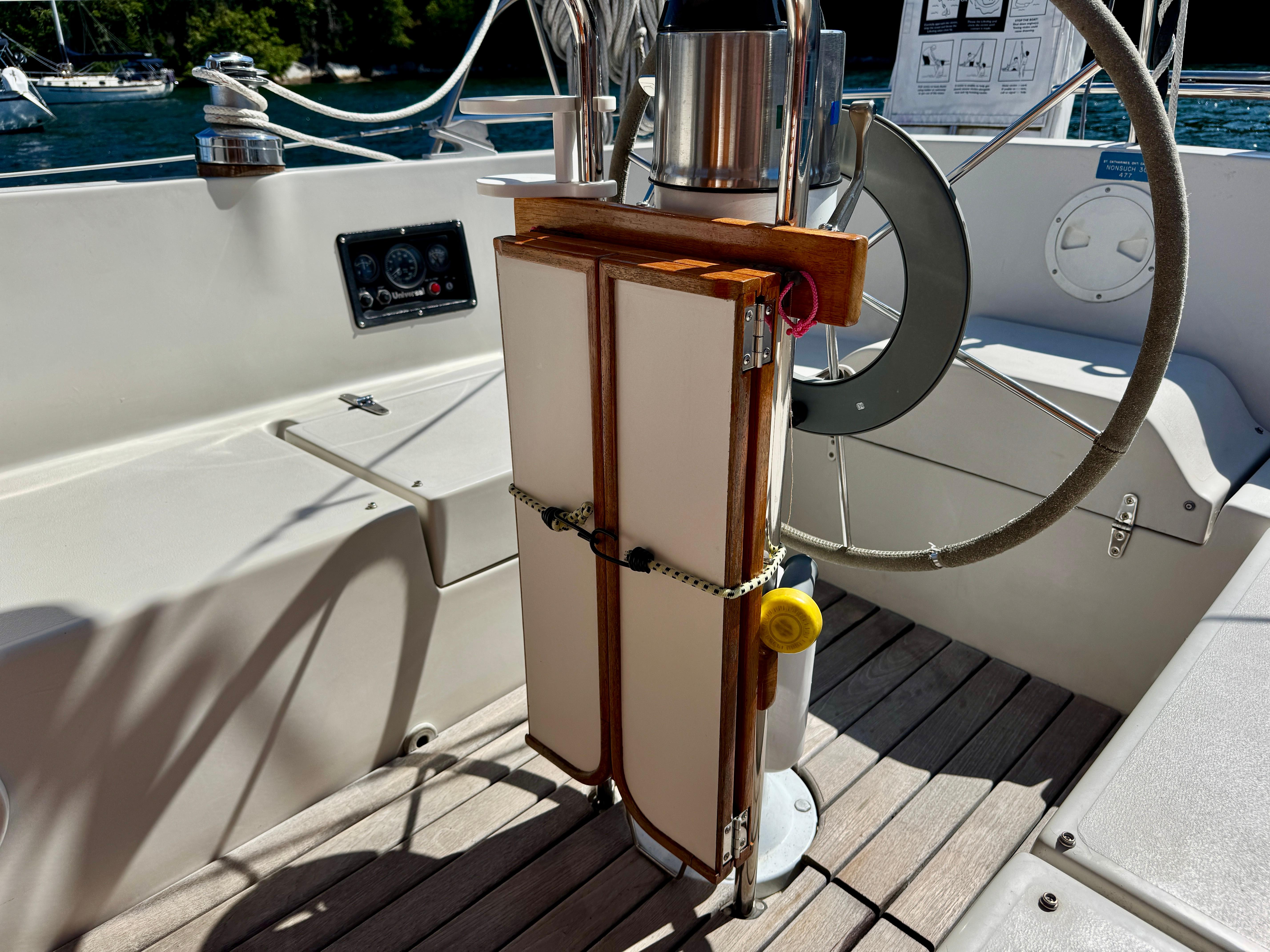 1989 Nonsuch 30 Ultra sailboat cockpit with steering wheel and navigation instruments.