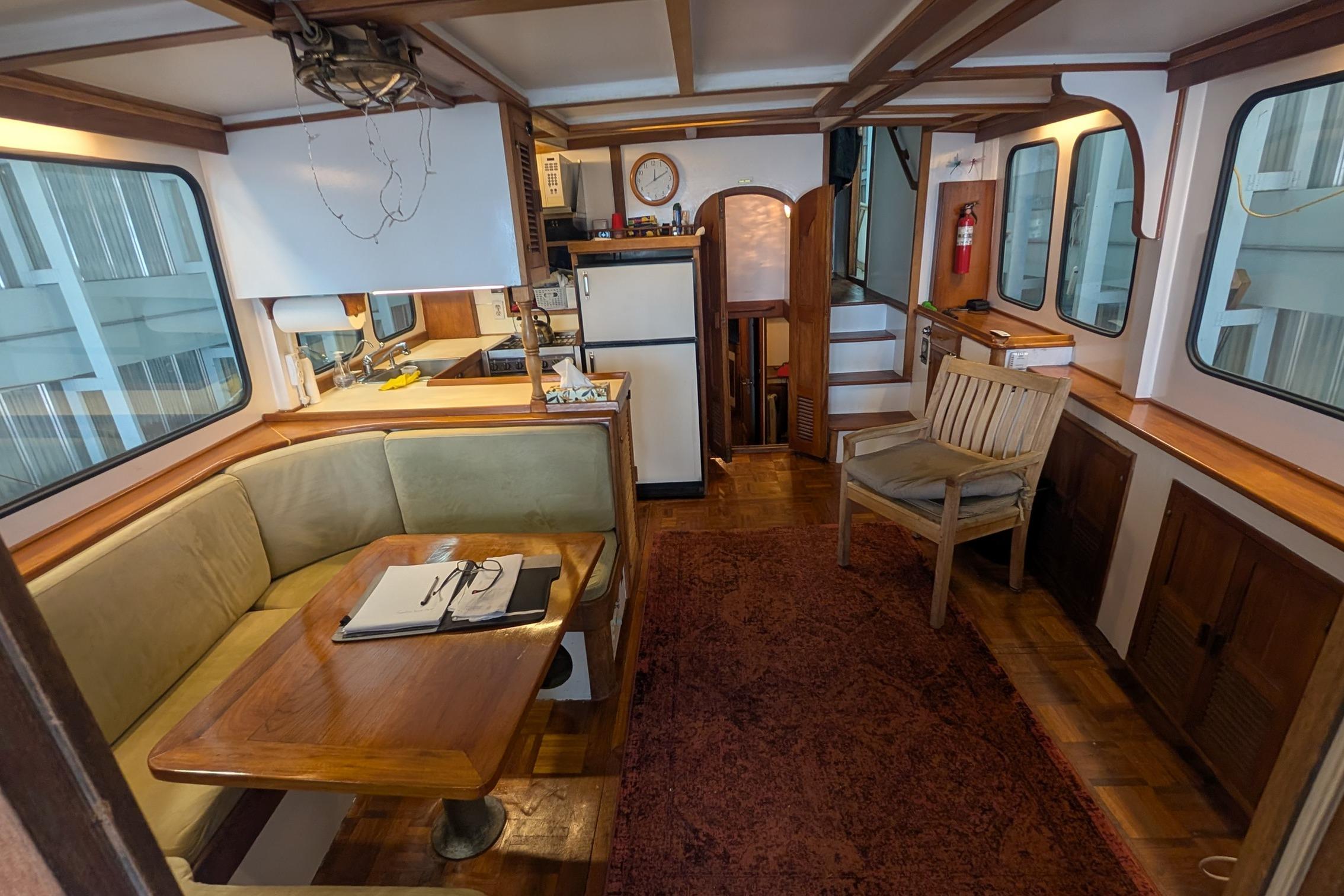 Interior of a 1979 Tai Chiao Custom boat with cozy seating and wooden furnishings.