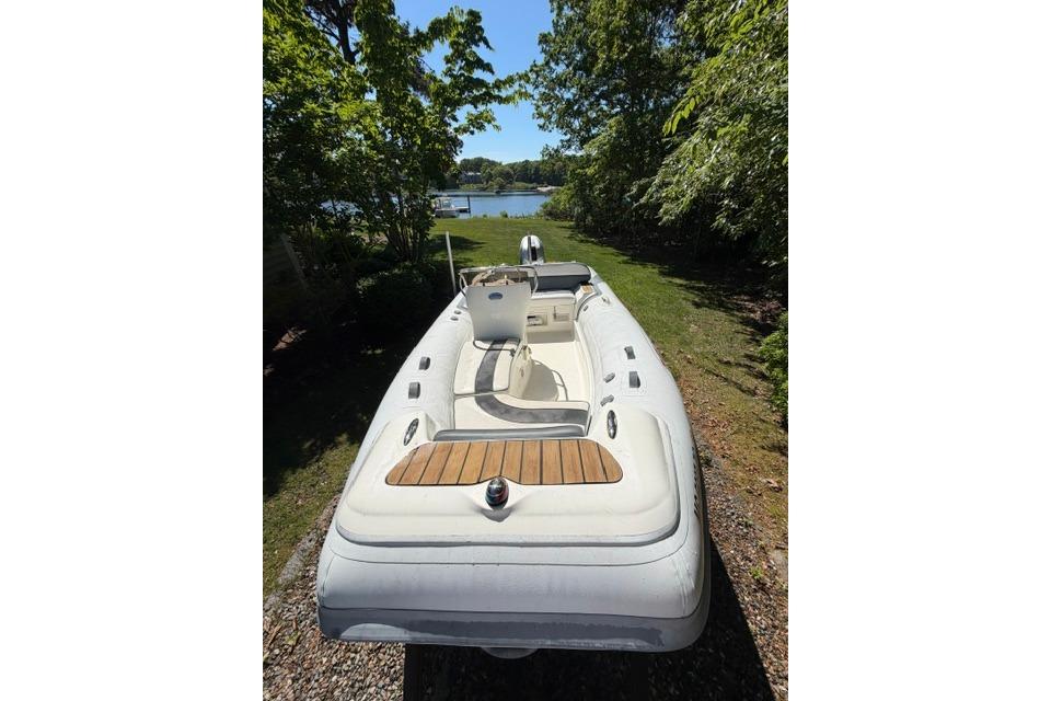 2016 Walker Bay Generation 450 DLX boat on grassy path near water.