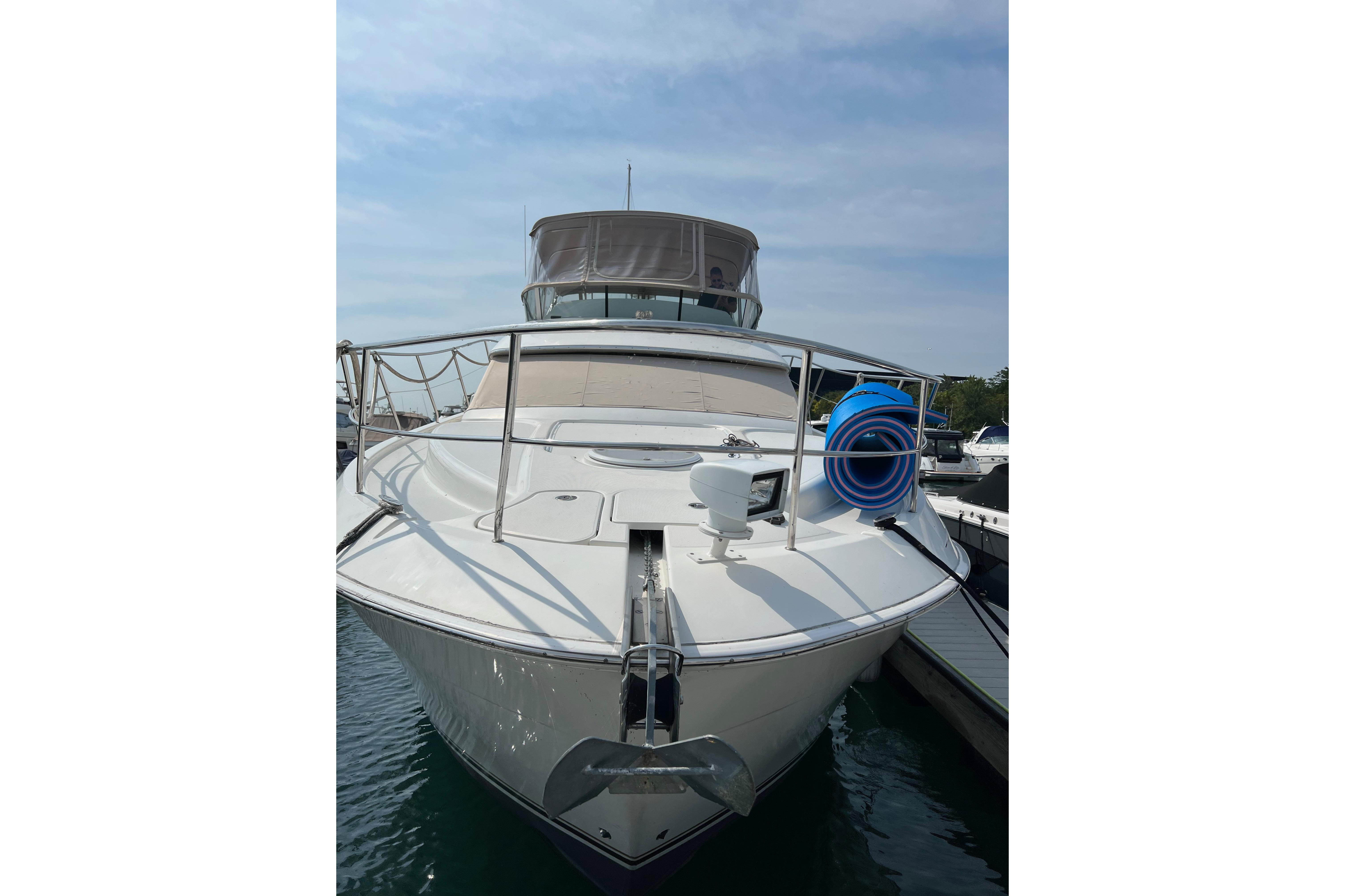 2006 Silverton 38 Sport Bridge yacht docked at marina, front view.
