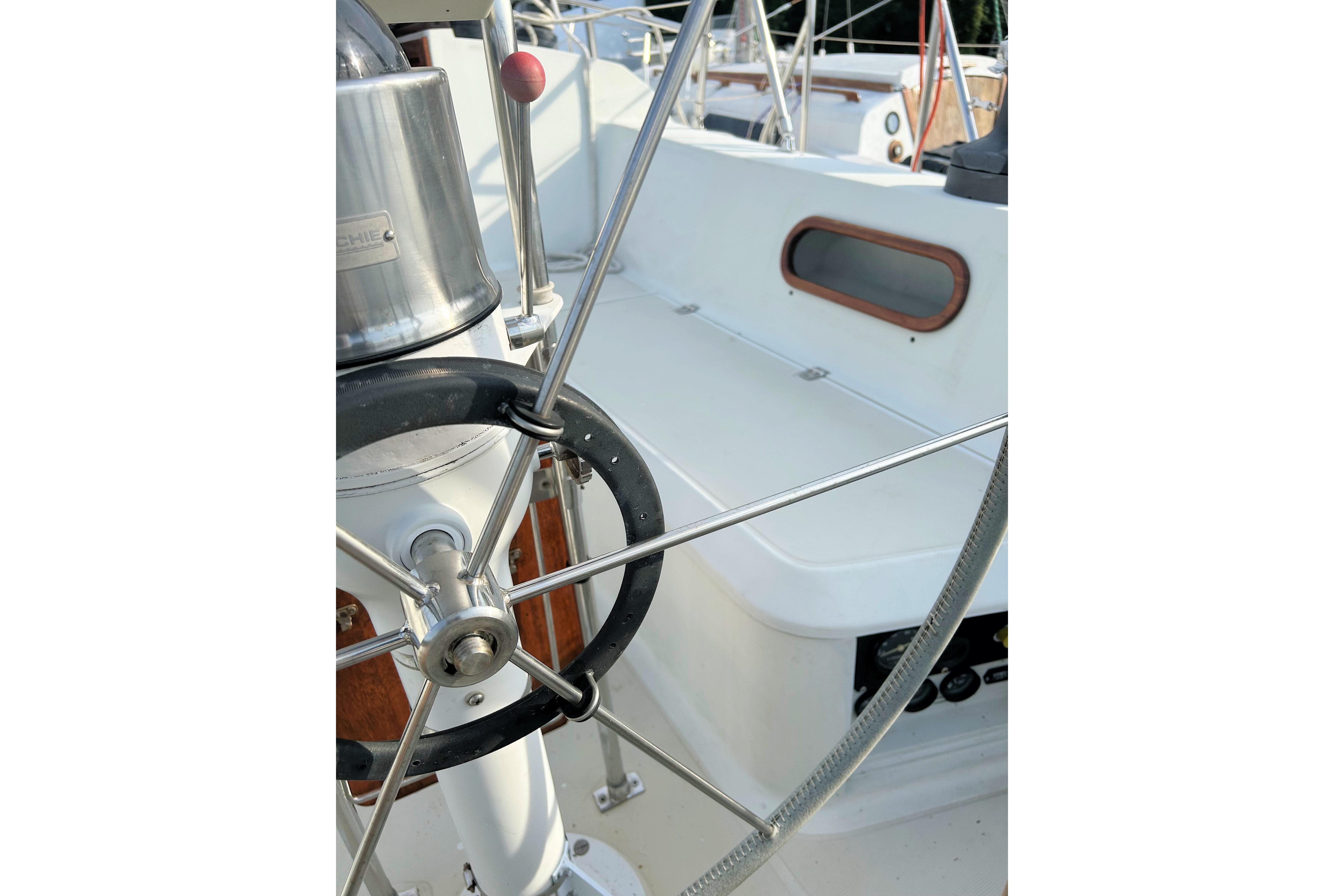 Cockpit of 1987 Ericson 38-200 sailboat with steering wheel and seating area.