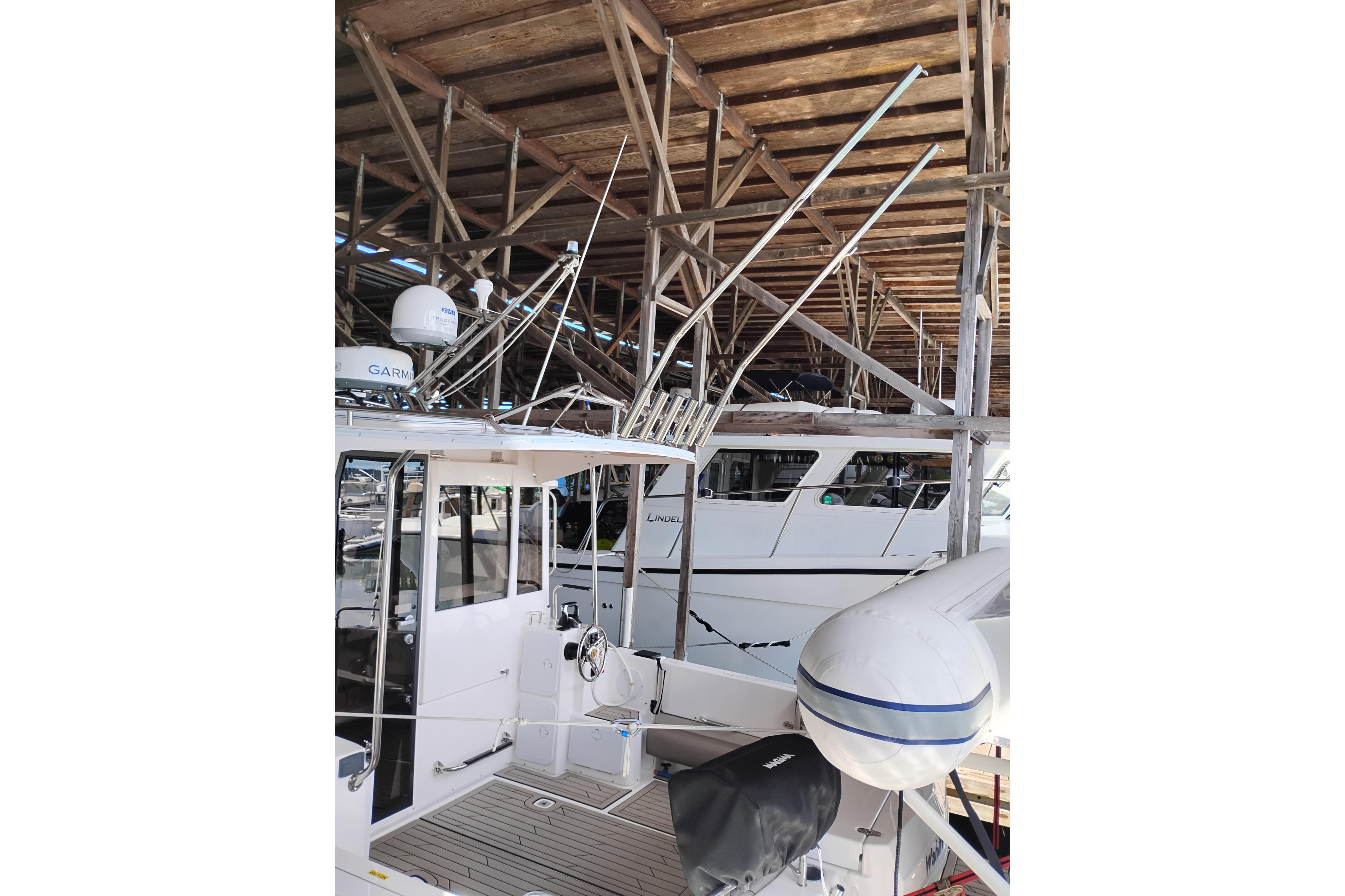 2022 Cutwater C-32 Coupe docked under wooden shelter, showcasing sleek design and modern features.