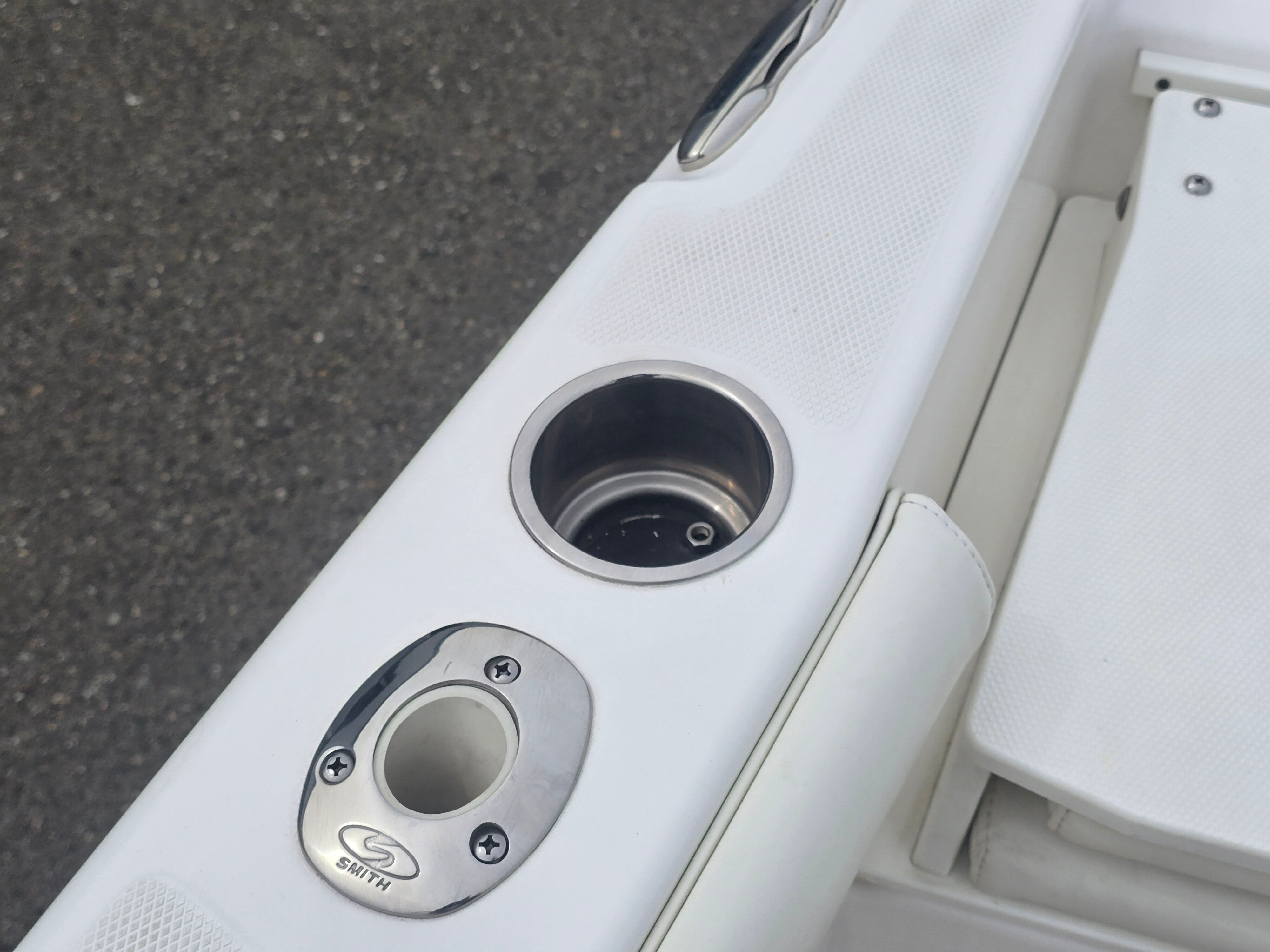 Close-up of a cup holder and fishing rod holder on a boat.