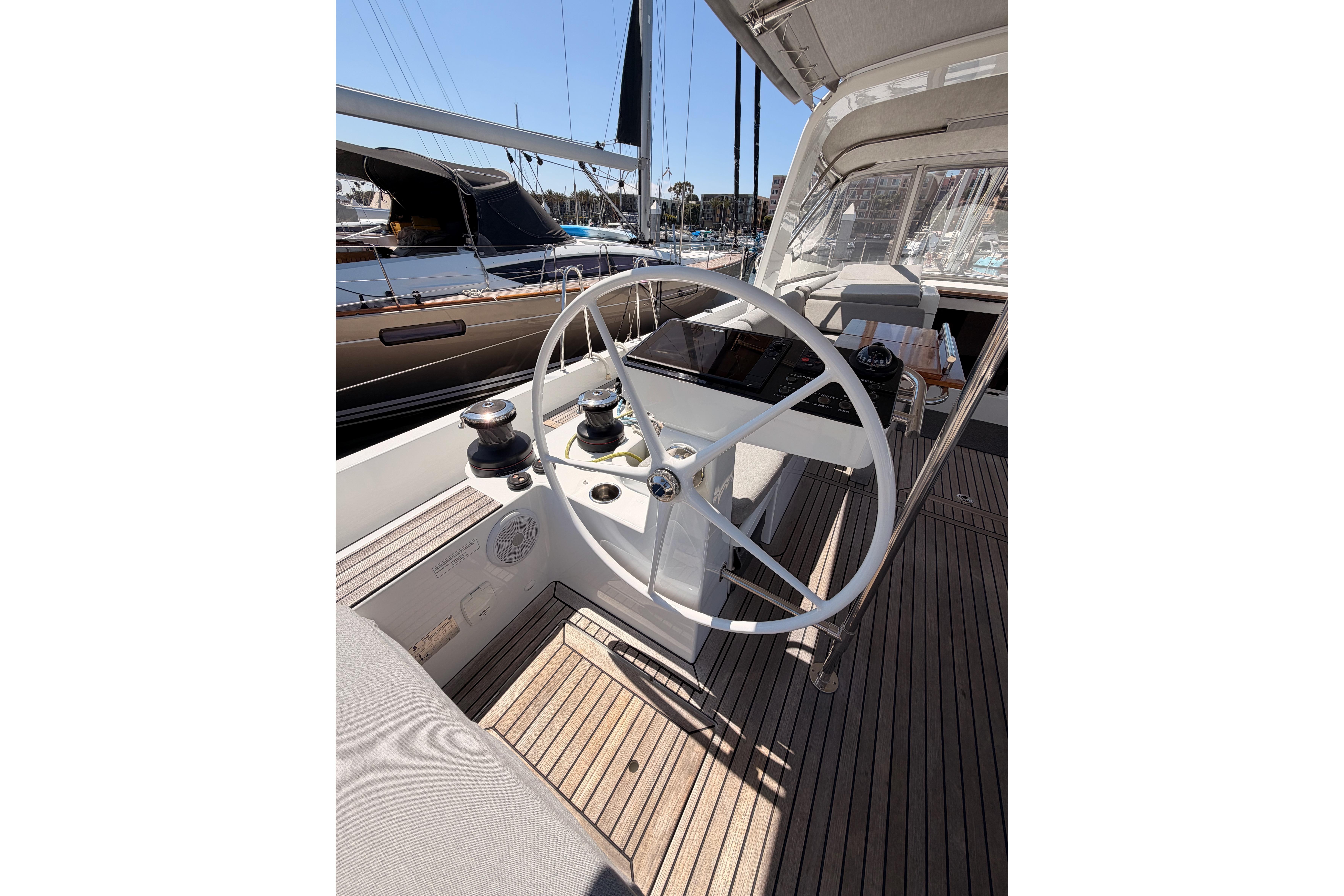 Steering wheel of 2022 Beneteau Oceanis Yacht 54, docked in a marina.