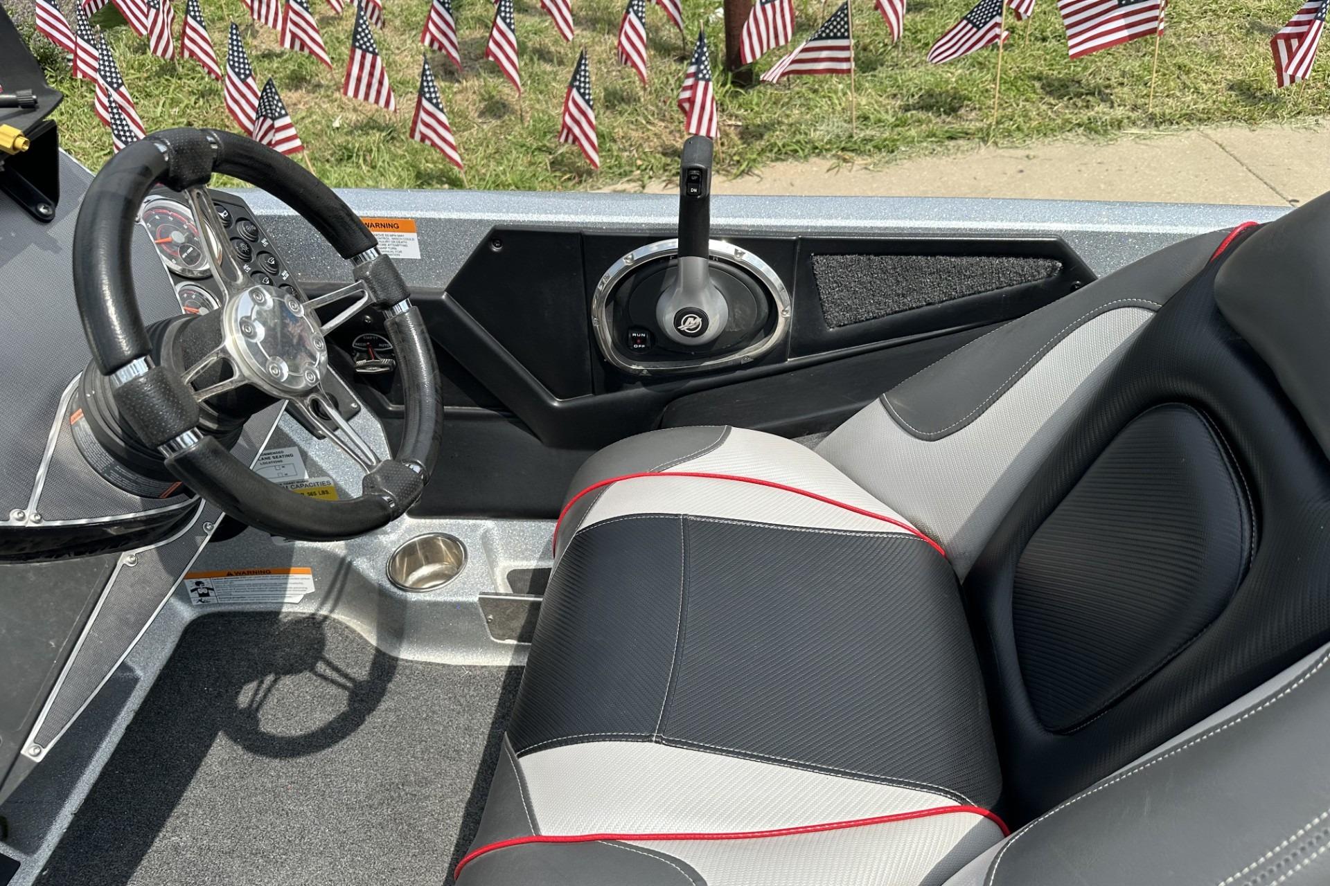 2018 Ranger Z518 boat interior with steering wheel, seat, and American flags in background.
