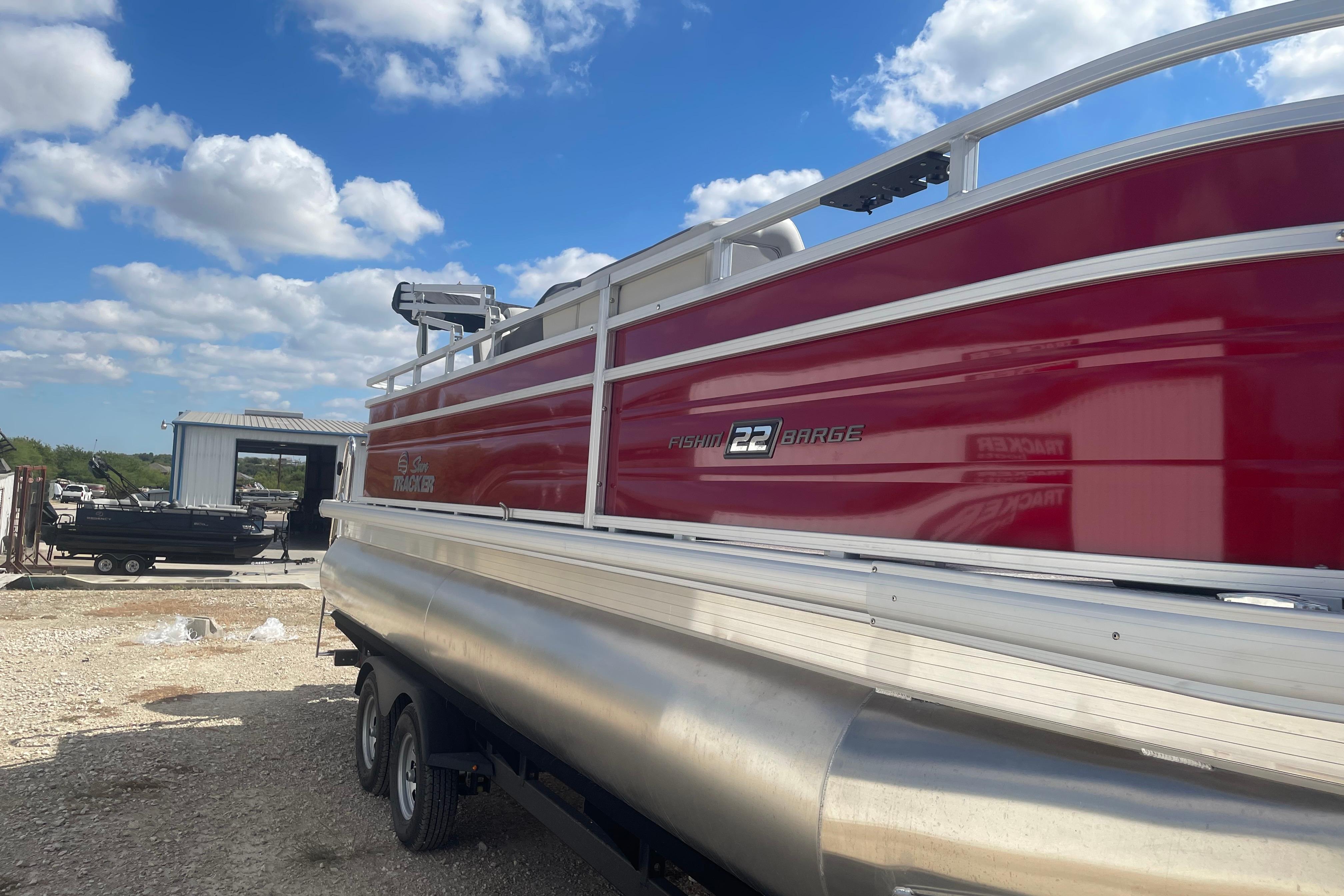 2026 Sun Tracker Fishin' Barge 22 DLX pontoon boat in a sunny outdoor setting.