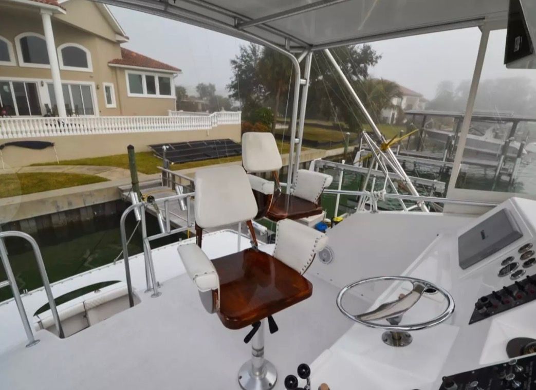 The image shows the helm of a 1979 Hatteras sport fishing boat with two swivel chairs.