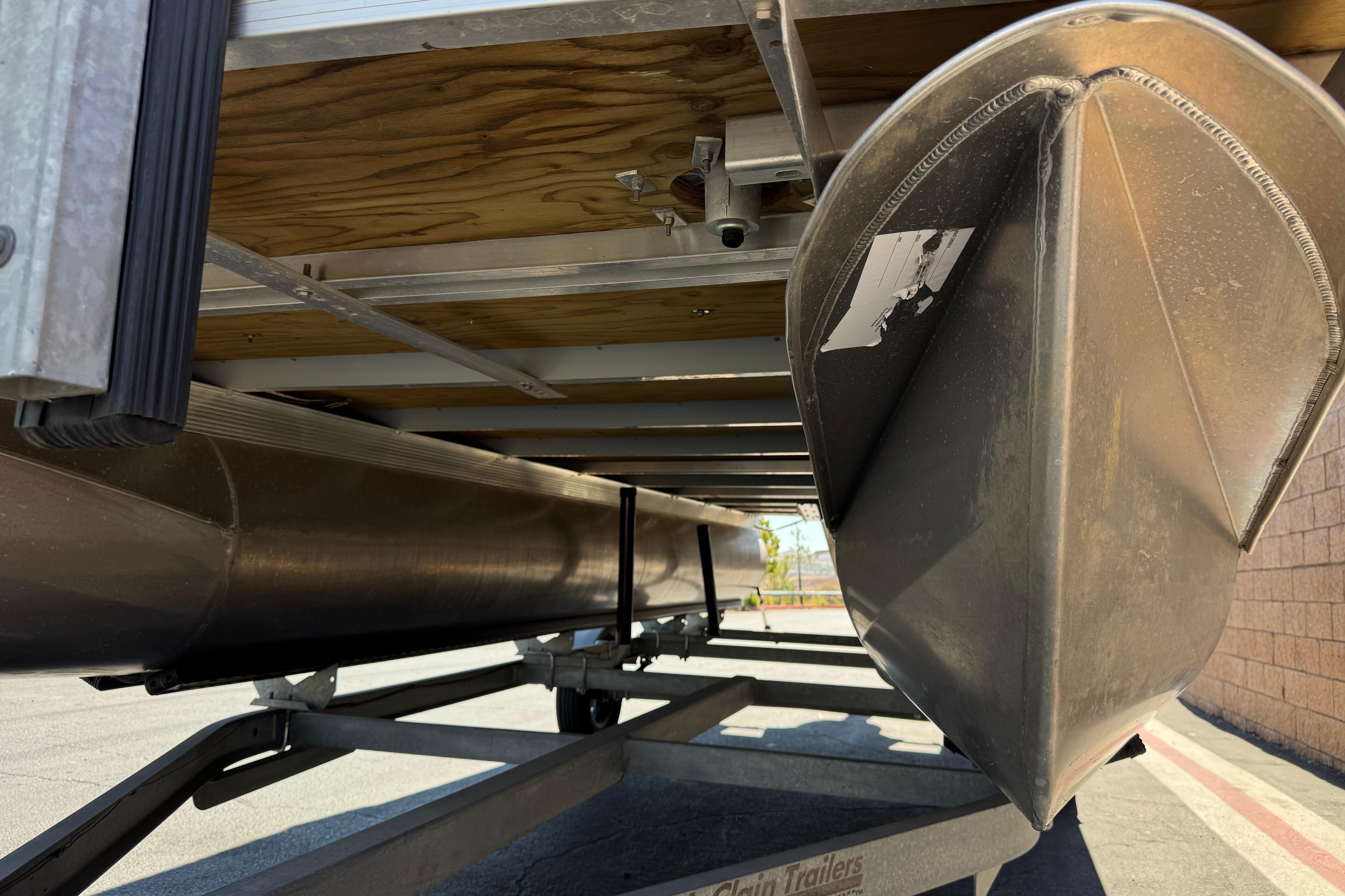 Underneath view of 2023 Avalon Venture Fish N Cruise pontoon boat on trailer.