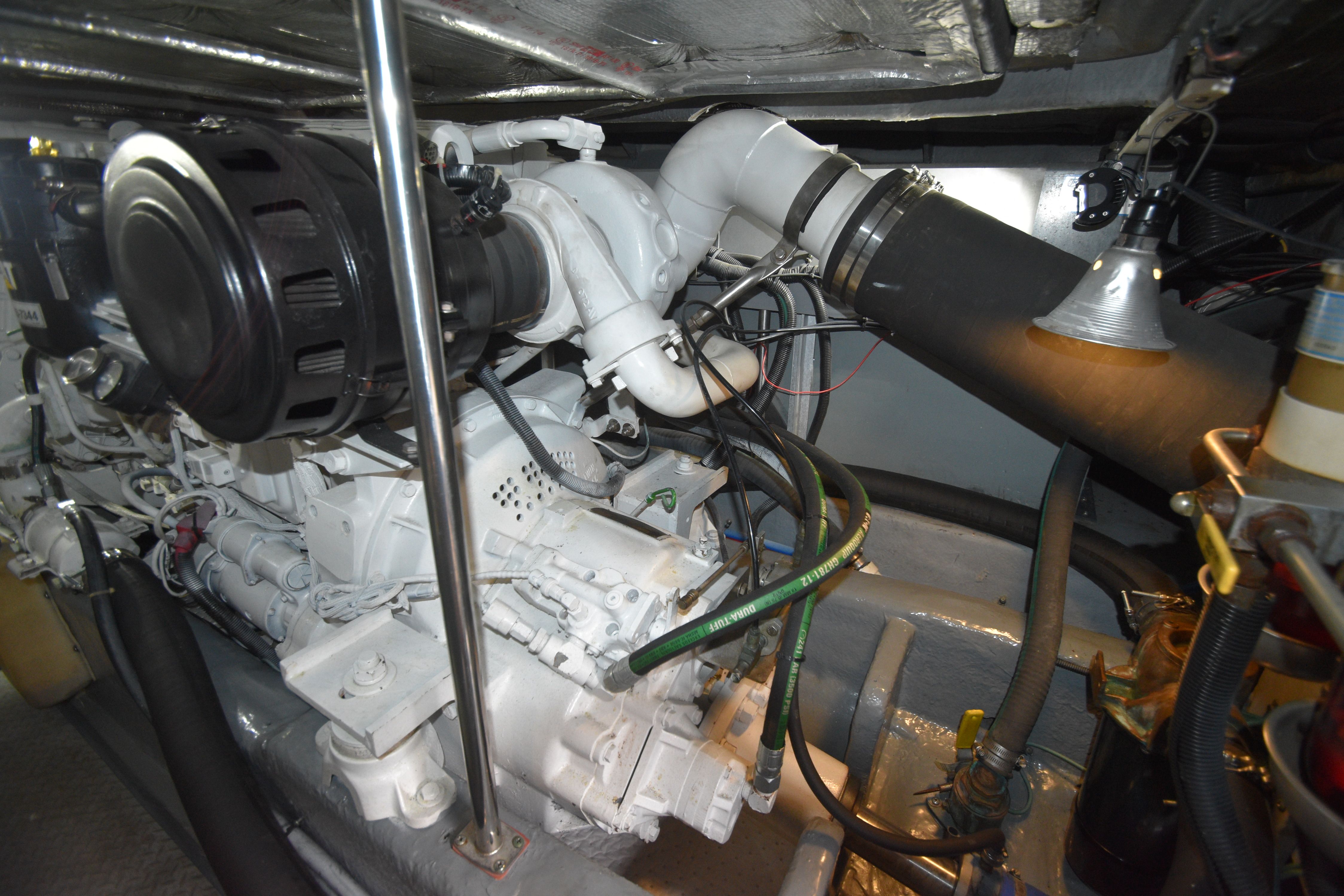 Engine room of the 2000 Sea Ray 480 Sedan Bridge with visible engine and piping.