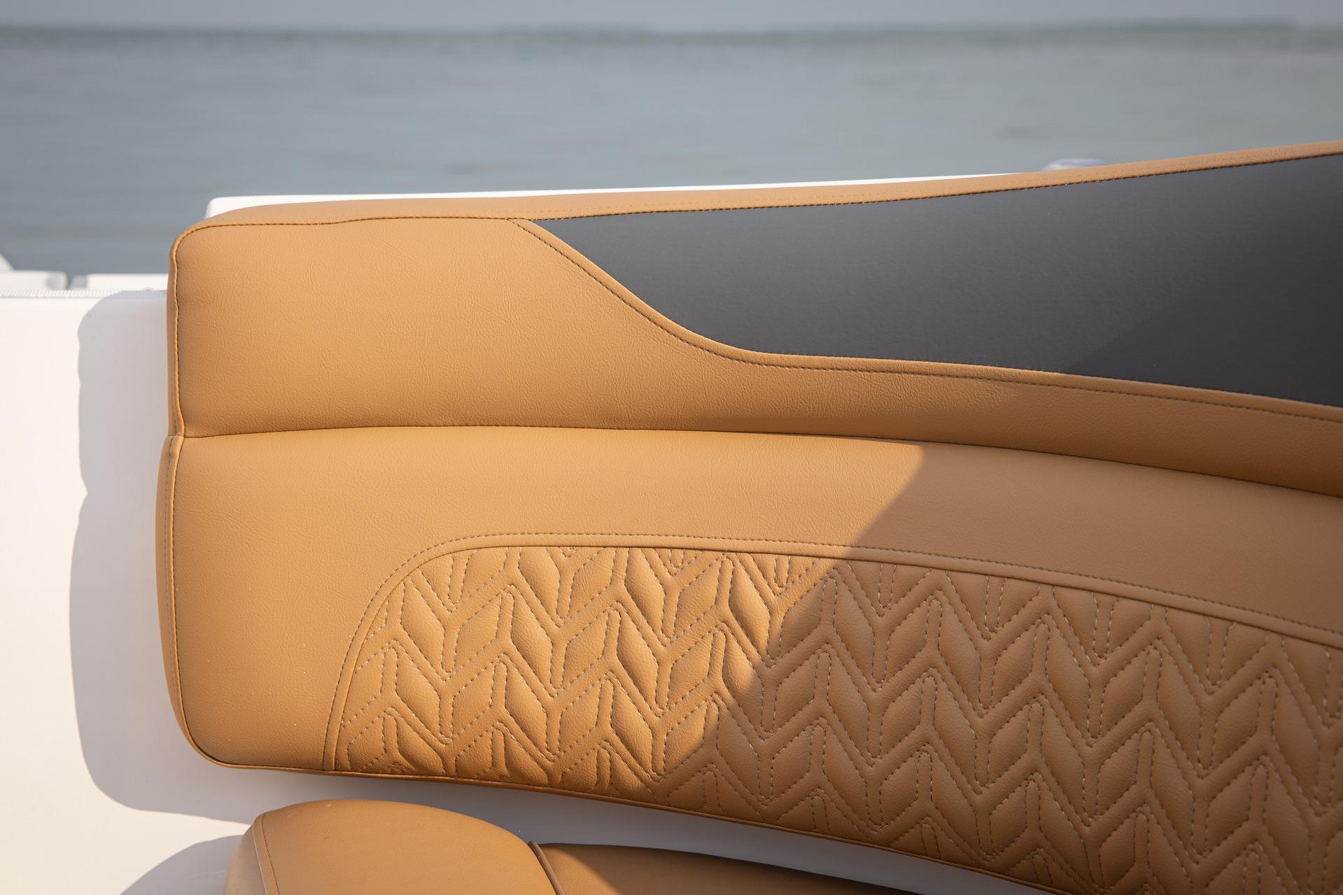 Luxurious tan seating on 2026 Hurricane SunDeck 2690 OB boat, featuring intricate stitching.