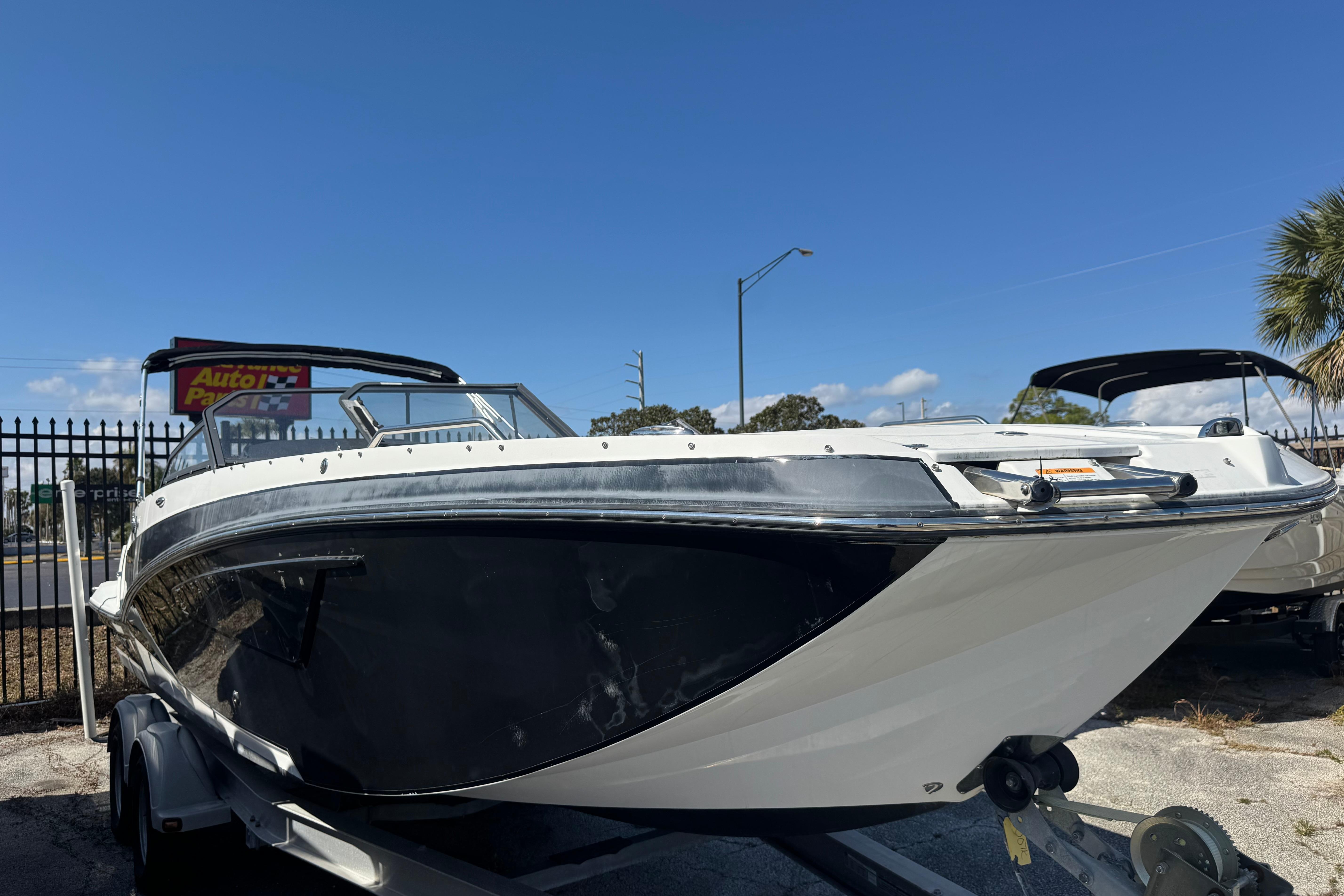 2020 Glastron GTD 240 boat on trailer under clear blue sky.