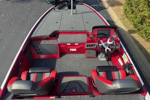 2026 Nitro Z19 XL Pro boat interior with red and gray seating, steering wheel, and dashboard.