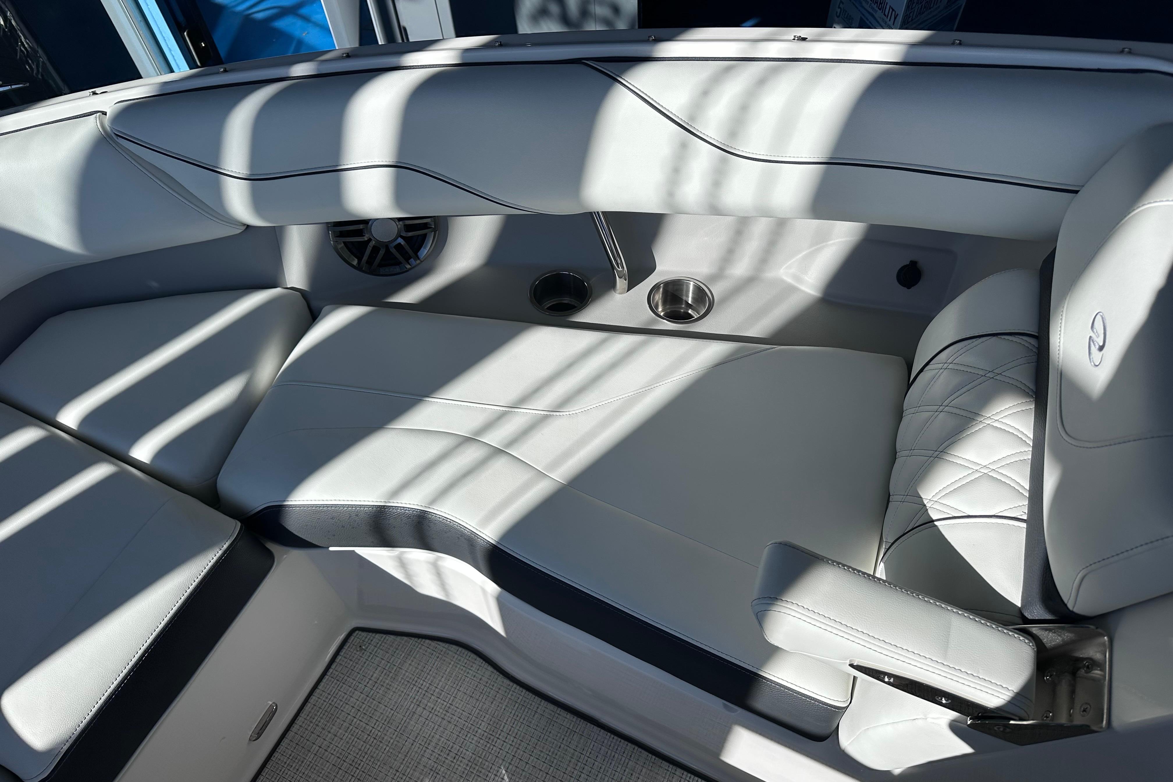 Luxurious interior of 2026 Regal LX4 boat with white leather seating and cup holders.