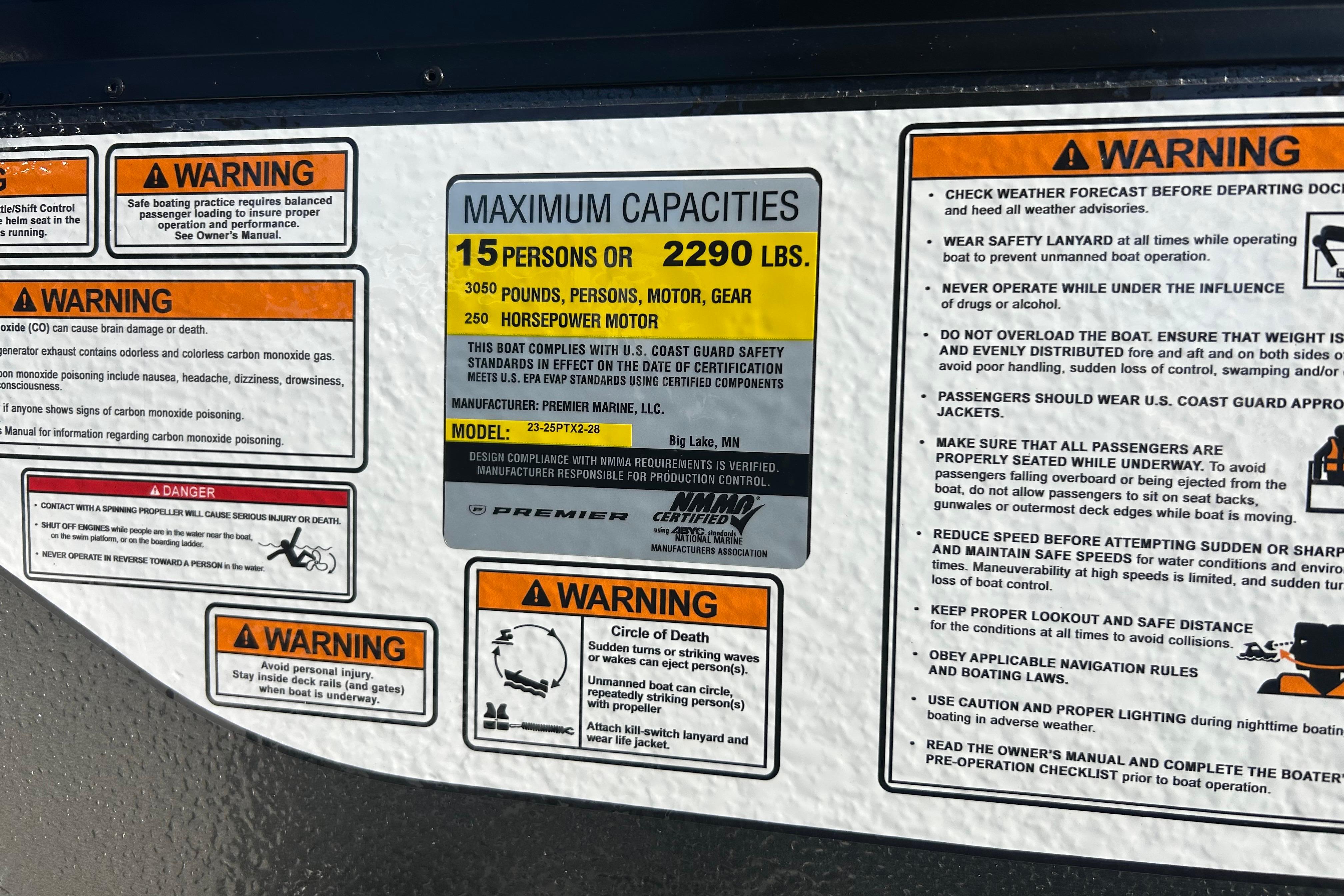 Warning labels and capacity information on a 2026 Premier 230 Sunsation Angler 4pt boat.