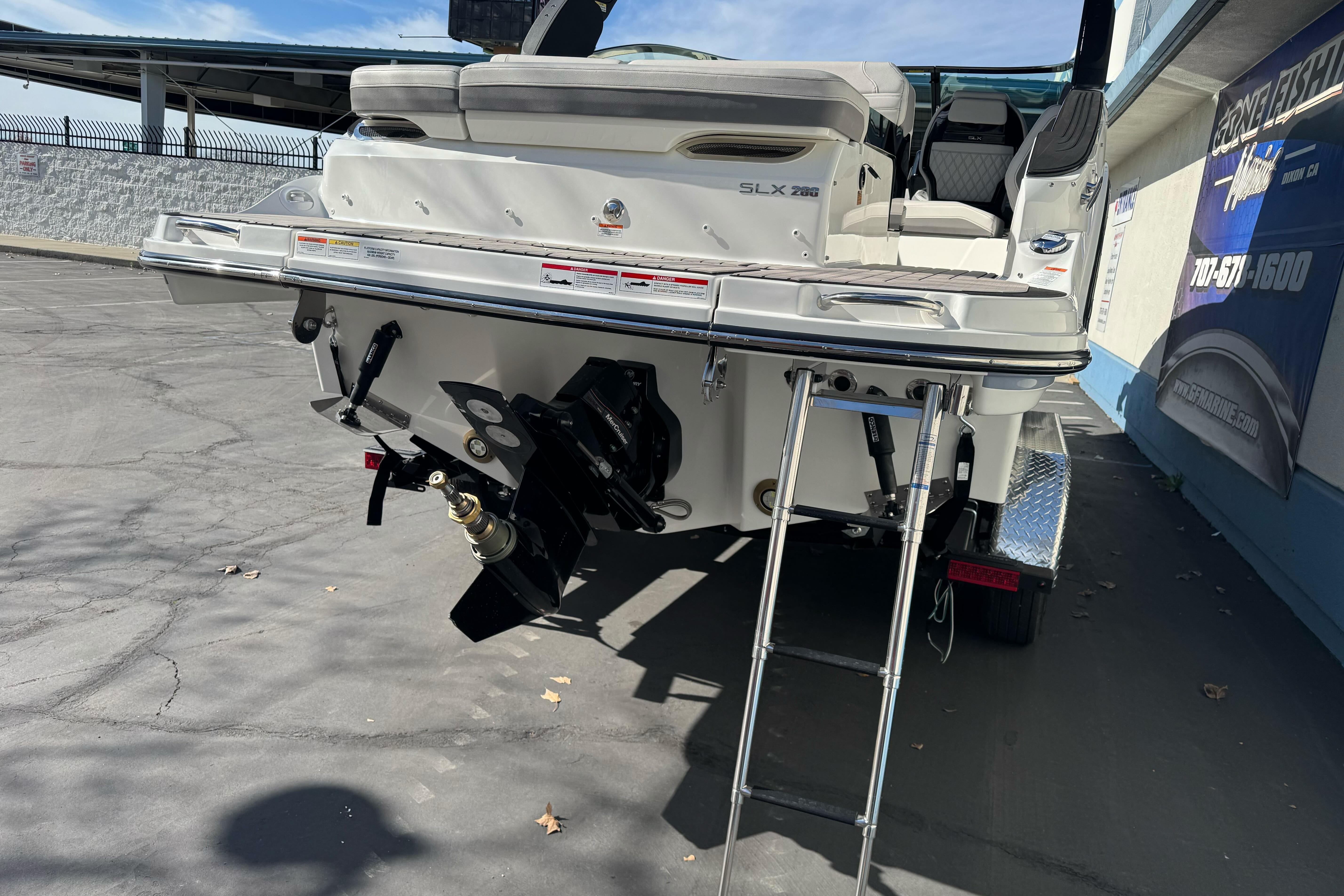 2026 Sea Ray SLX 260 boat rear view with ladder and outboard motor.