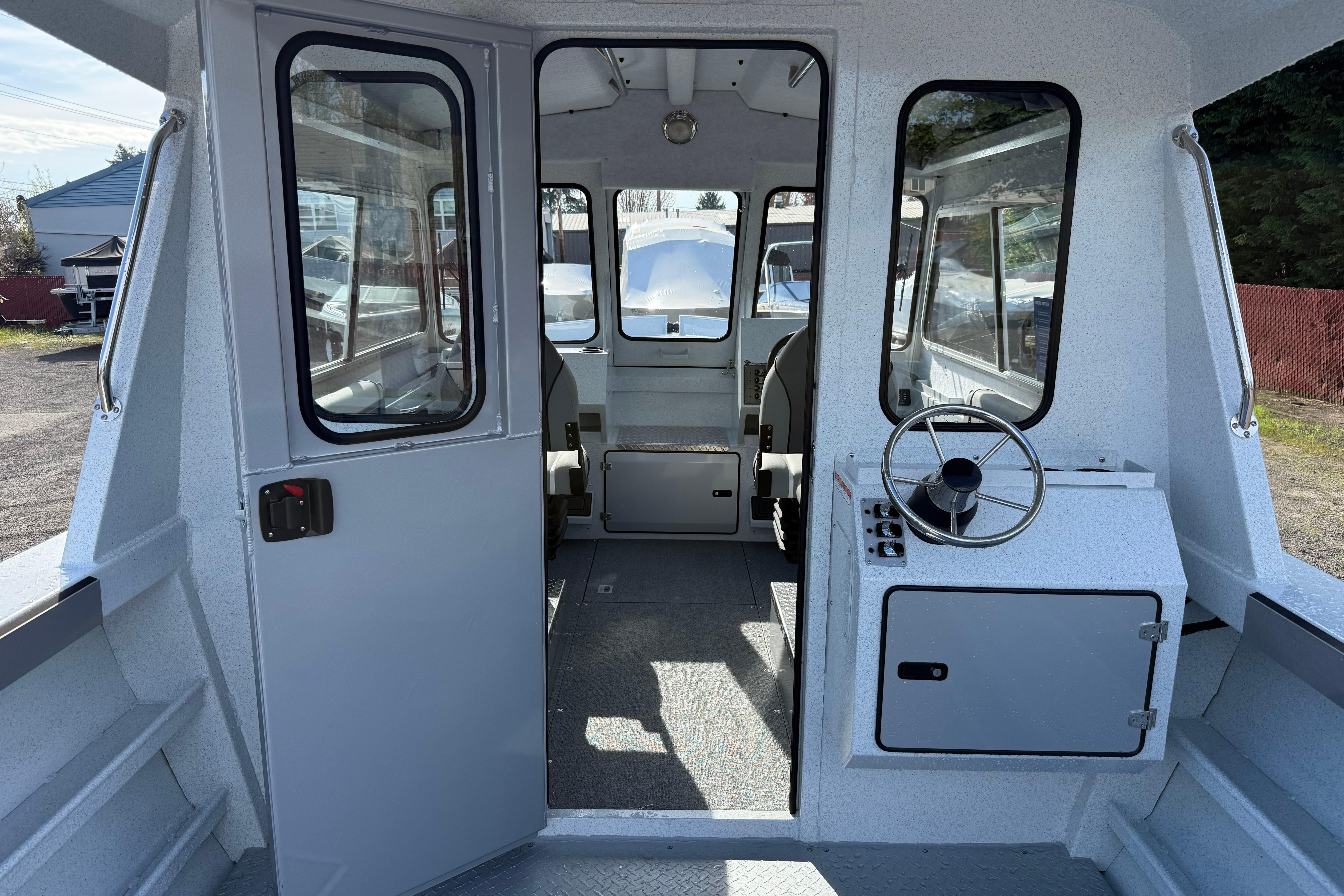 Interior view of 2026 KingFisher 2425 Escape HT boat, showcasing helm and seating area.