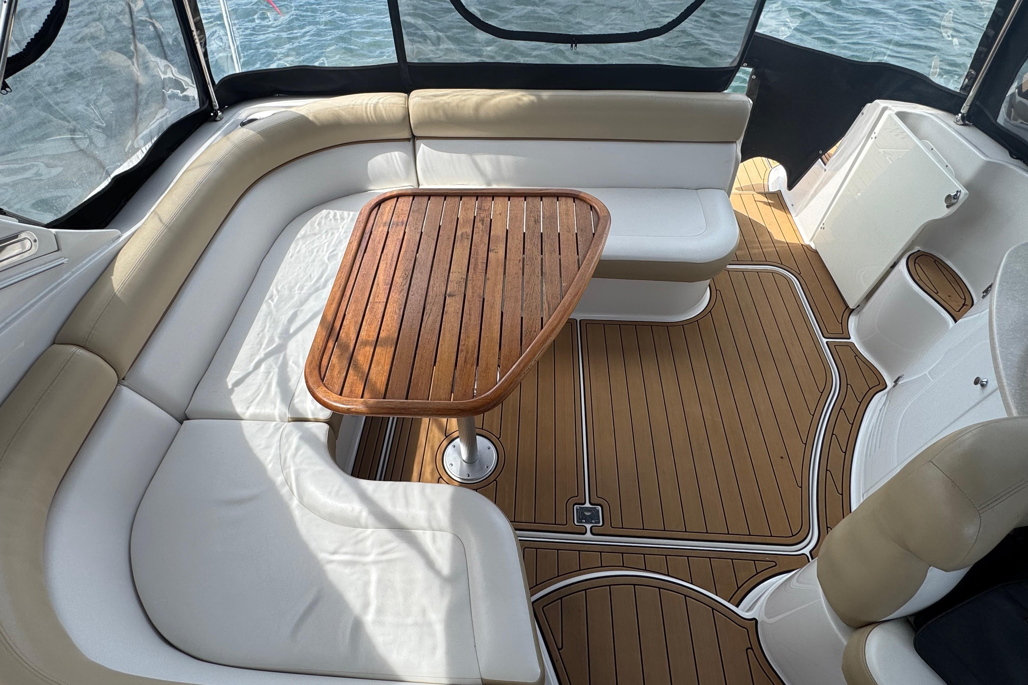 2009 Four Winns V358 boat interior with wooden table and cushioned seating.