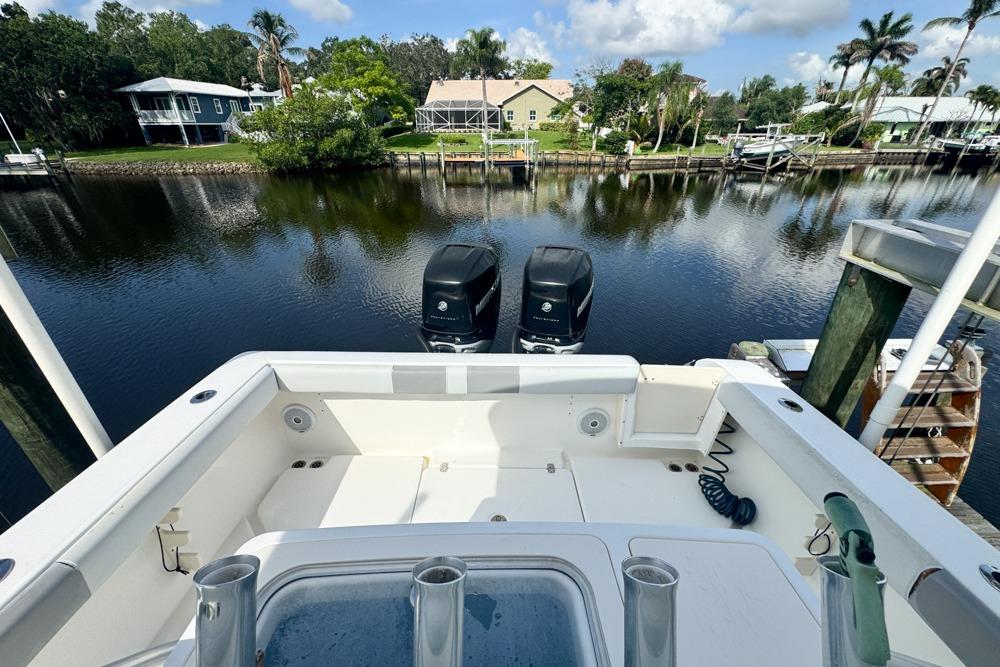 2018 Mako 284 Center Console boat docked by a scenic waterfront.