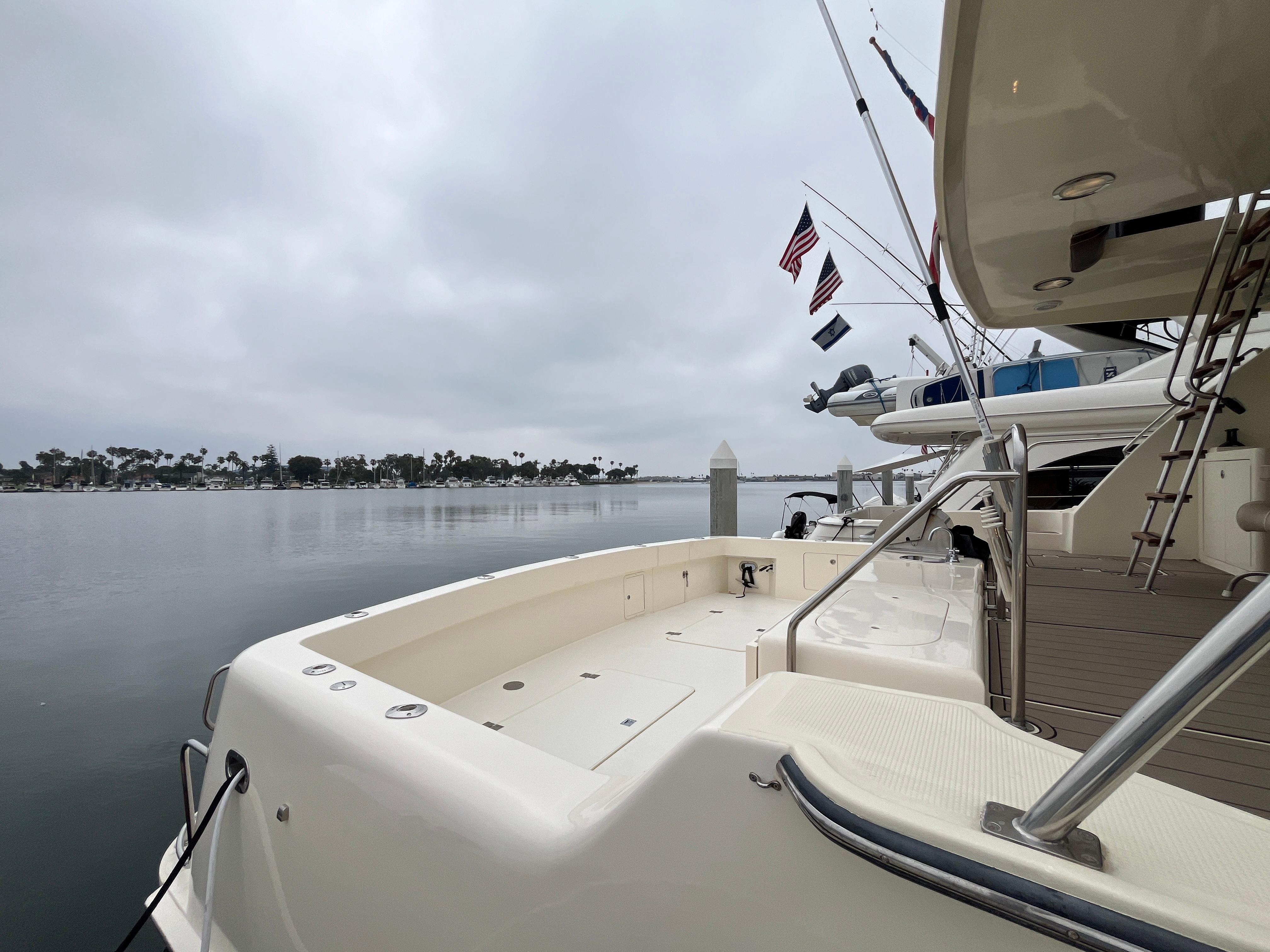 1999 Mikelson Long-Range Luxury Sportfisher docked by calm waters under cloudy skies.