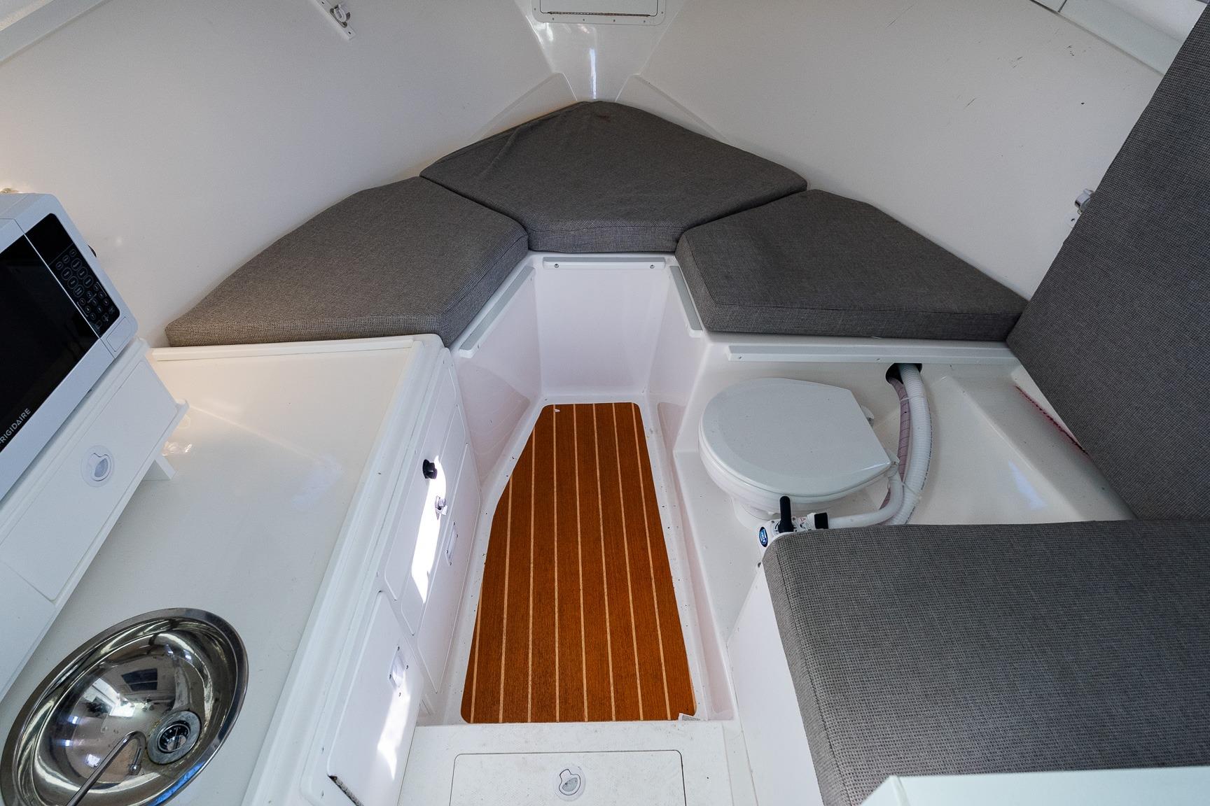 2024 Steiger Craft 31 Fisherman cabin interior with seating, sink, and microwave.