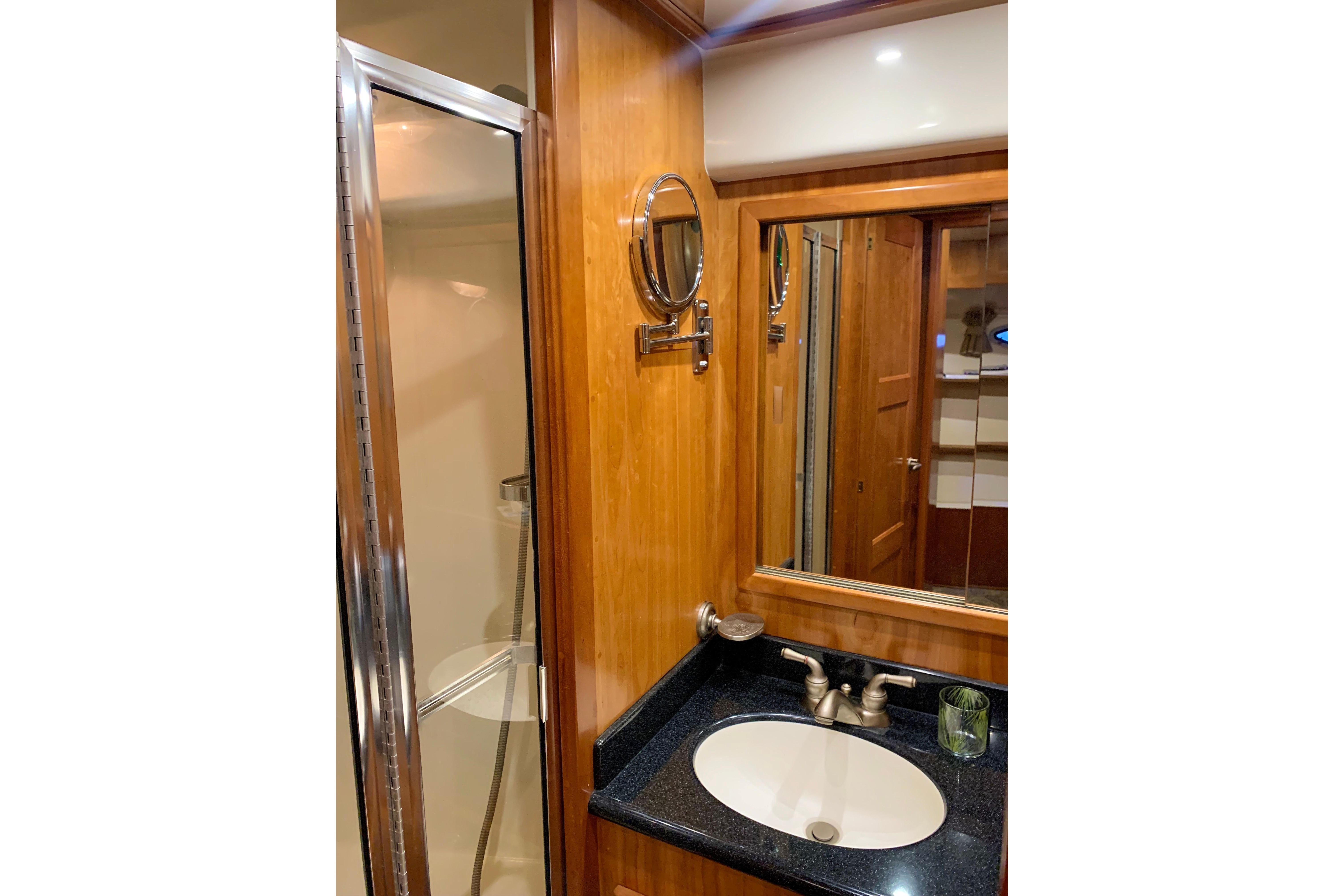 Luxurious bathroom in 2007 Navigator 5100 yacht with wood accents and modern fixtures.