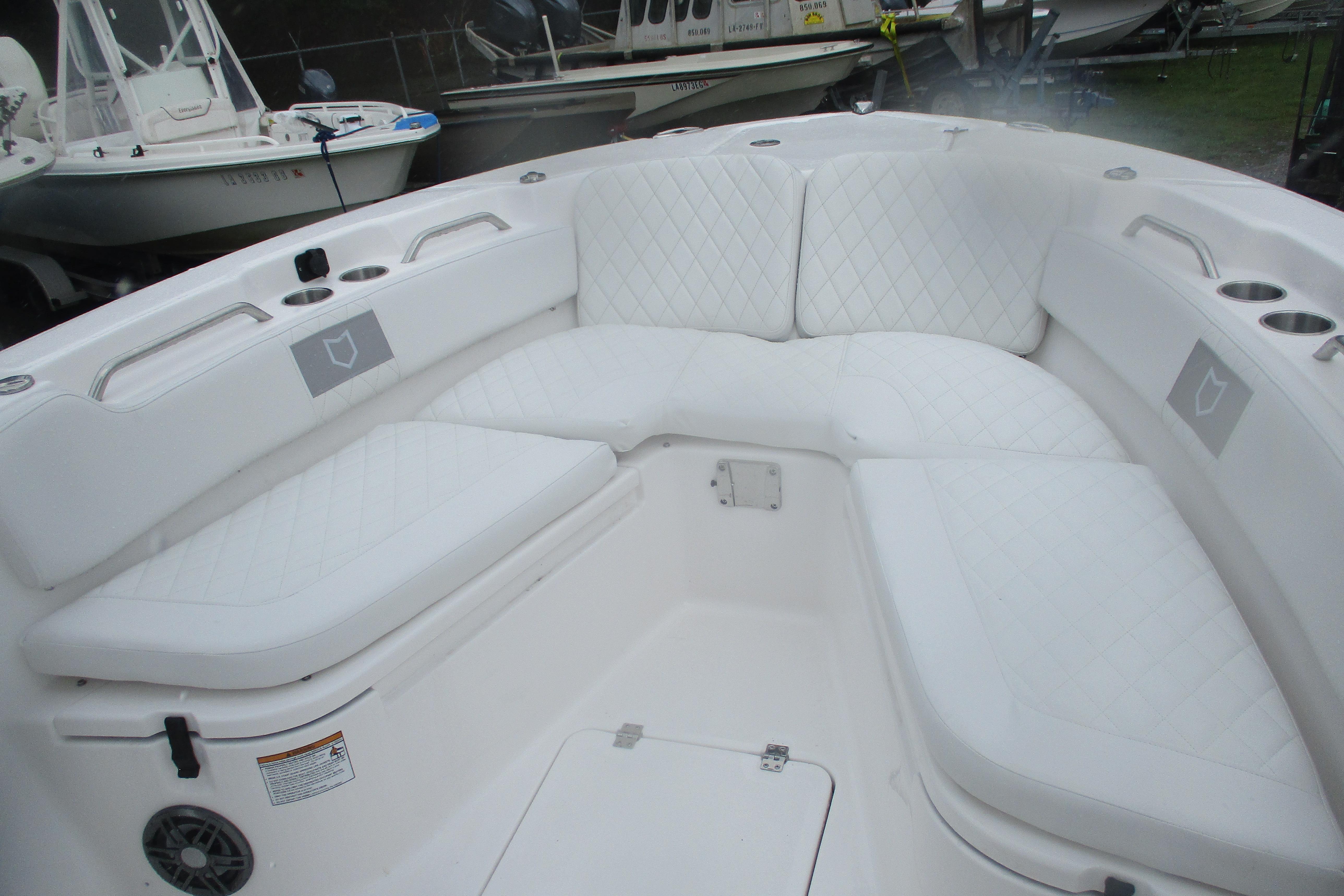 2026 Sea Fox 248 Commander boat interior with white cushioned seating and cup holders.