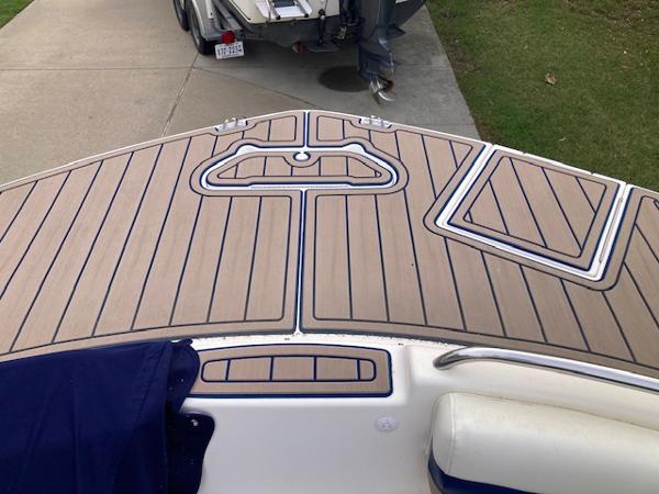 2006 Hurricane SunDeck 237 OB boat deck with wood finish and blue accents.
