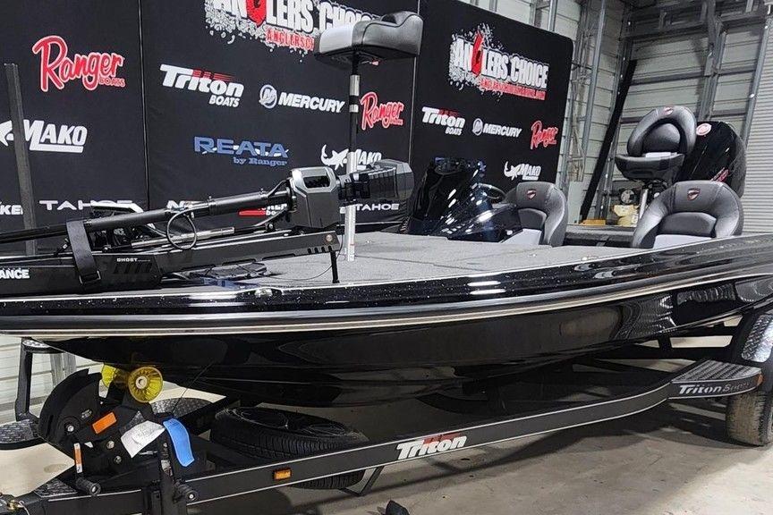 2026 Triton 20XP Patriot boat displayed indoors with branded backdrop.