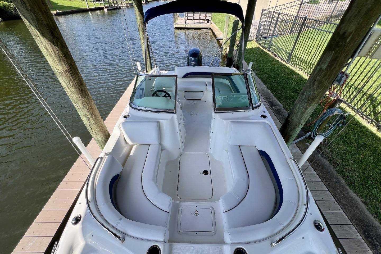 2013 Hurricane SunDeck 187 OB boat docked, featuring spacious seating and sleek design.