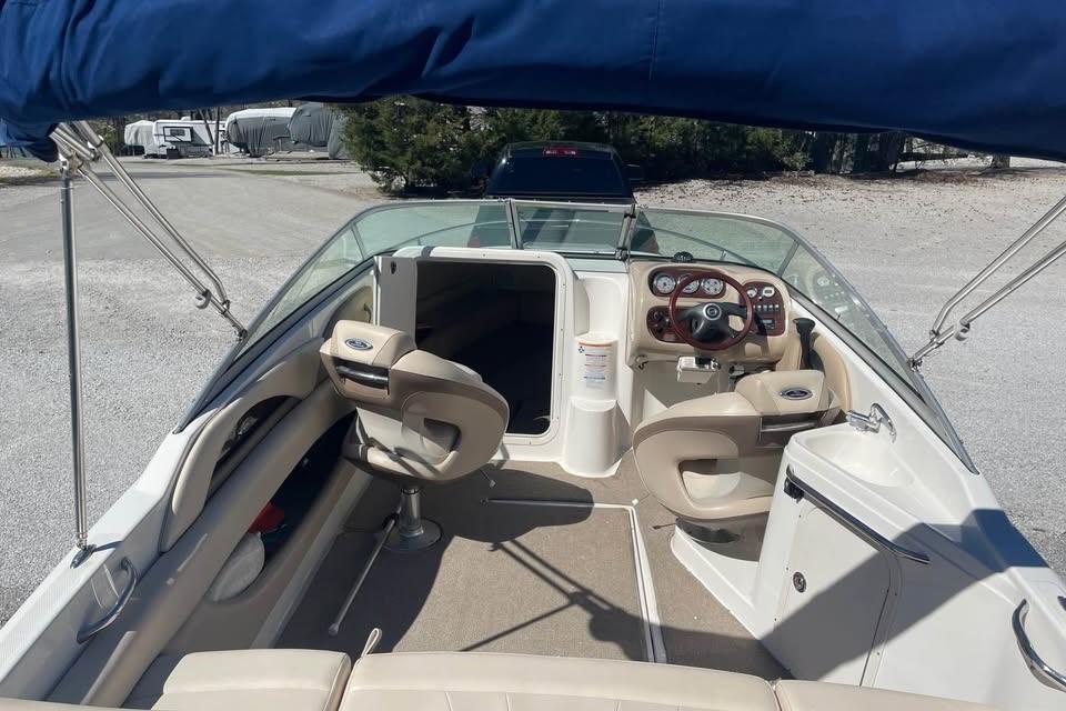 2007 Chaparral 215 SSi boat interior with seating and steering wheel under blue canopy.