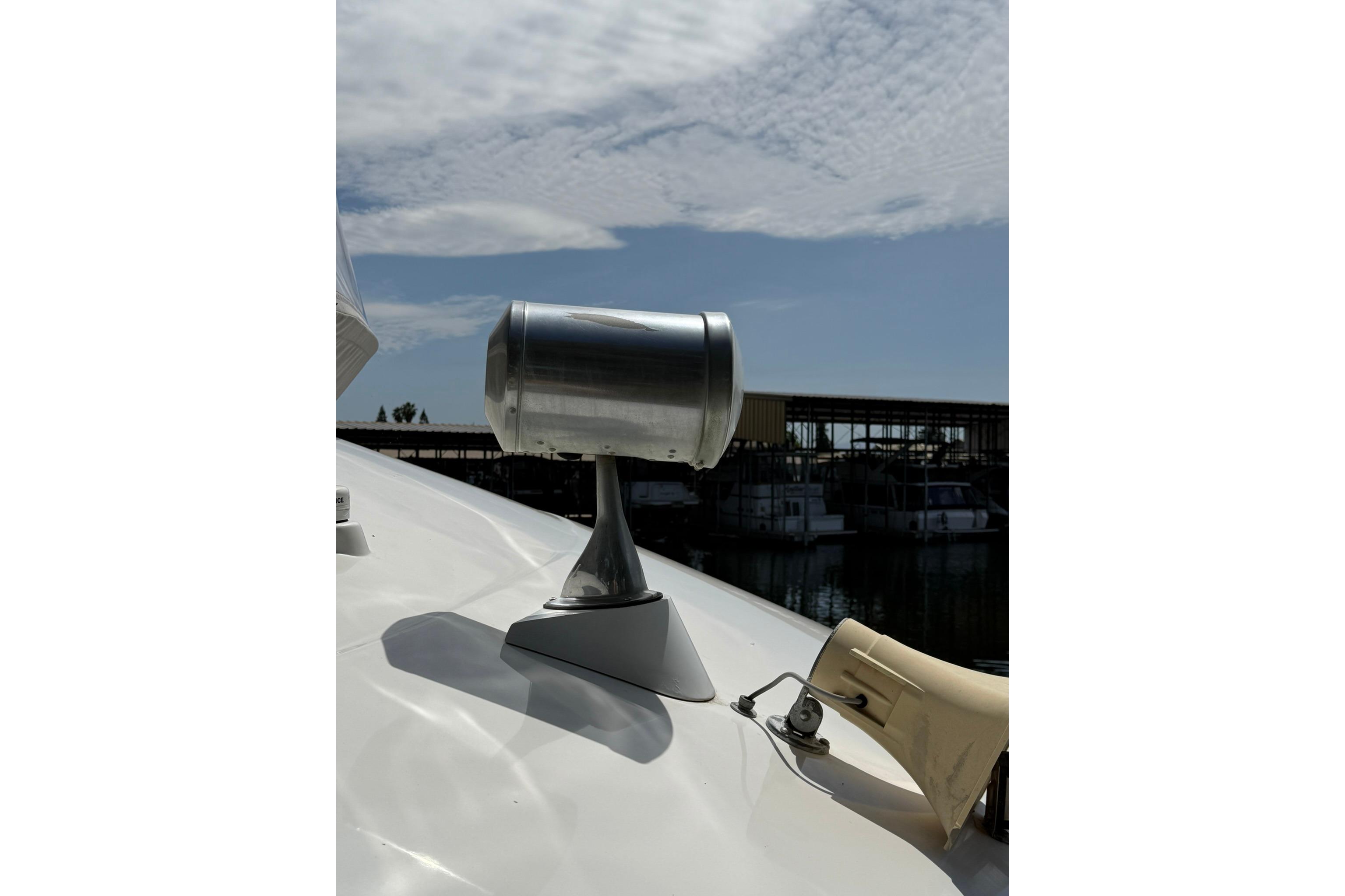 1991 Bayliner 4387 Motoryacht spotlight and horn on deck under cloudy sky.