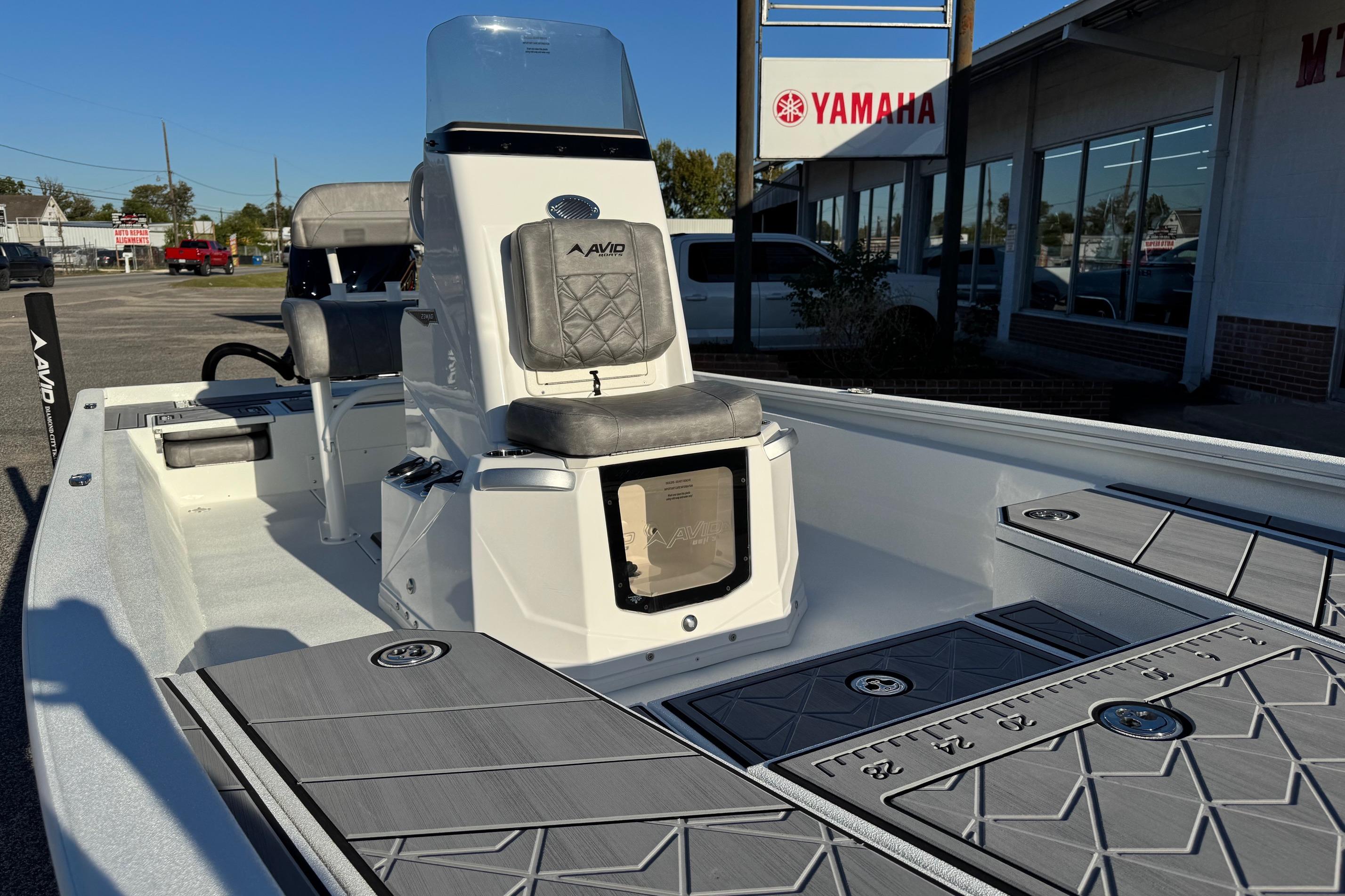 2025 Avid 23 Mag boat interior with seating and storage, displayed at a Yamaha dealership.