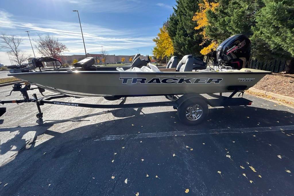 2026 Tracker Pro Team 190 boat on trailer in parking lot, surrounded by autumn trees.