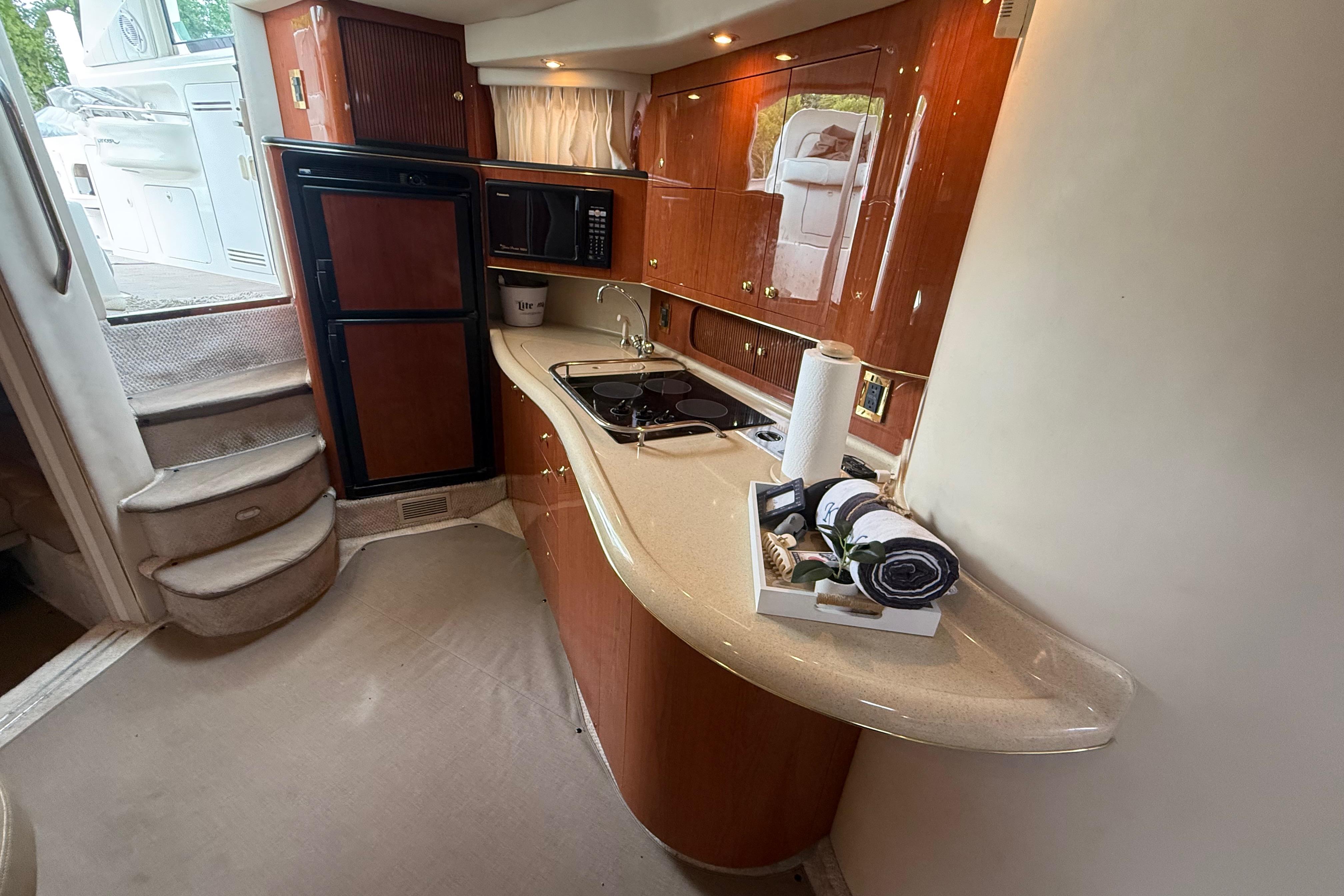 1998 Sea Ray Sundancer 400 yacht interior with kitchenette, featuring wood cabinetry and modern appliances.