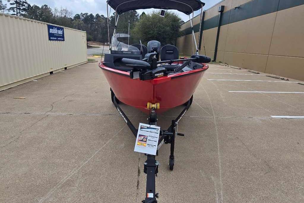 2026 Tracker Pro Guide V-16 SC boat in parking lot, red hull, trailer attached.