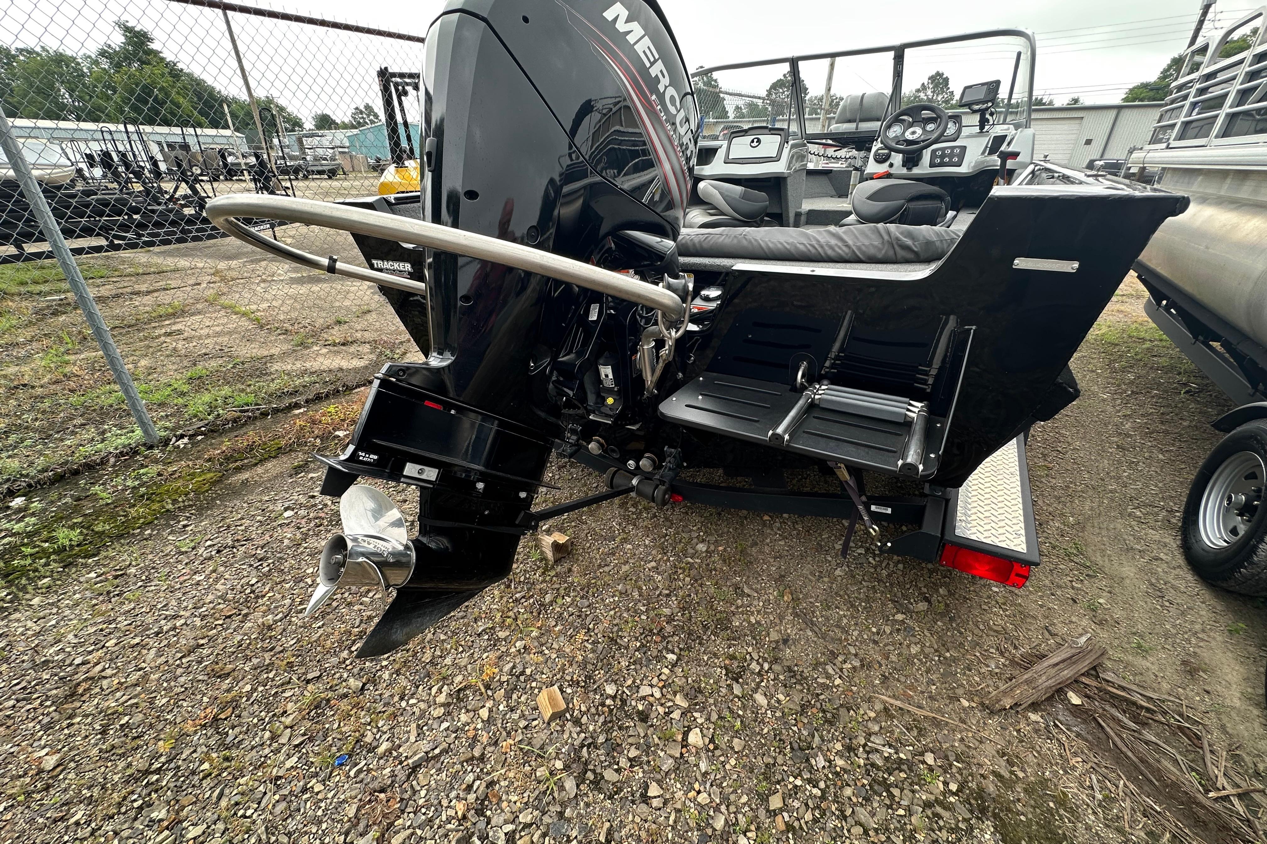 2018 Tracker Pro Guide V-175 Combo boat with Mercury outboard motor, parked on gravel.