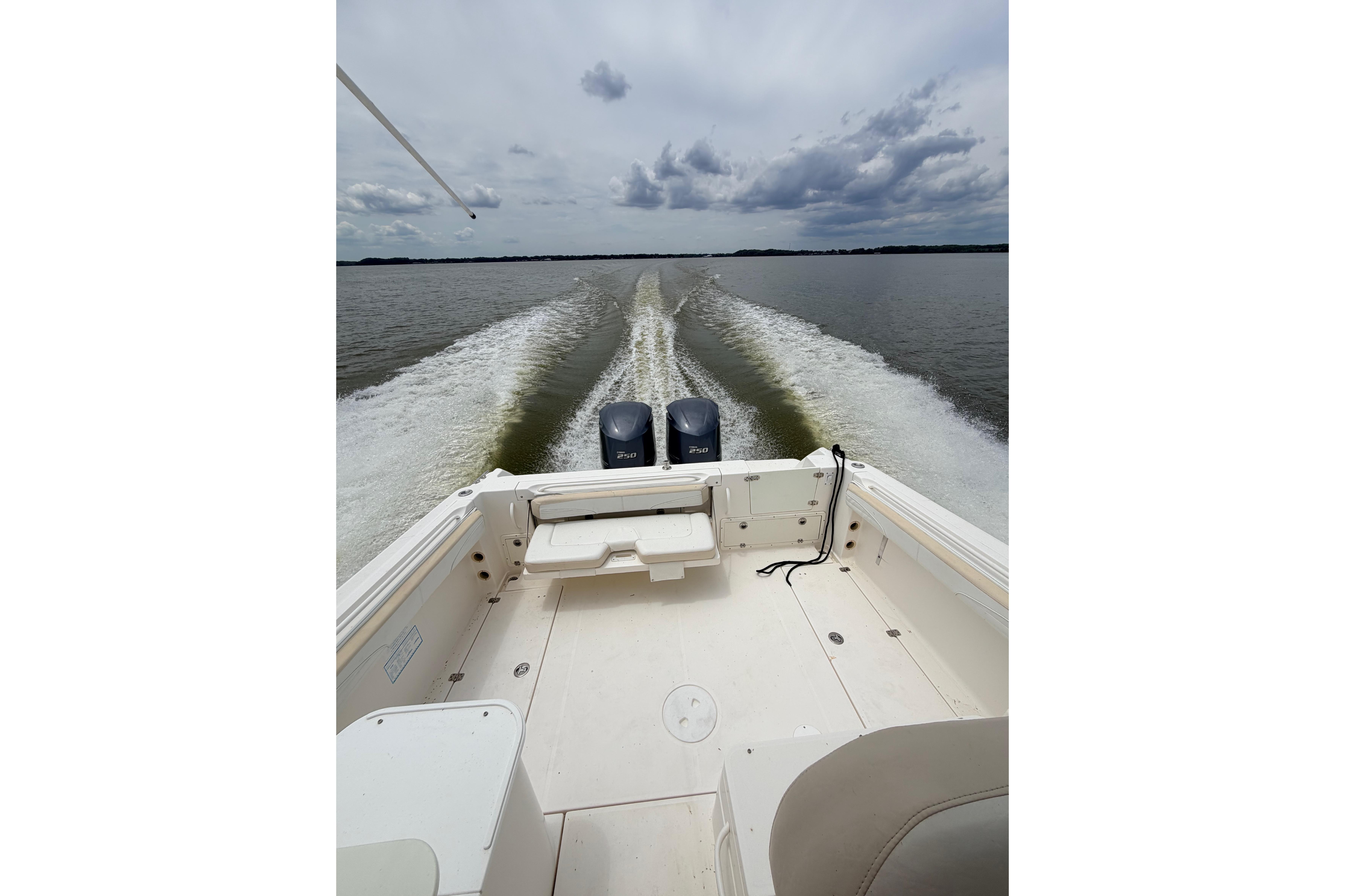 2015 Wellcraft 290 Coastal boat cruising on open water with twin engines.