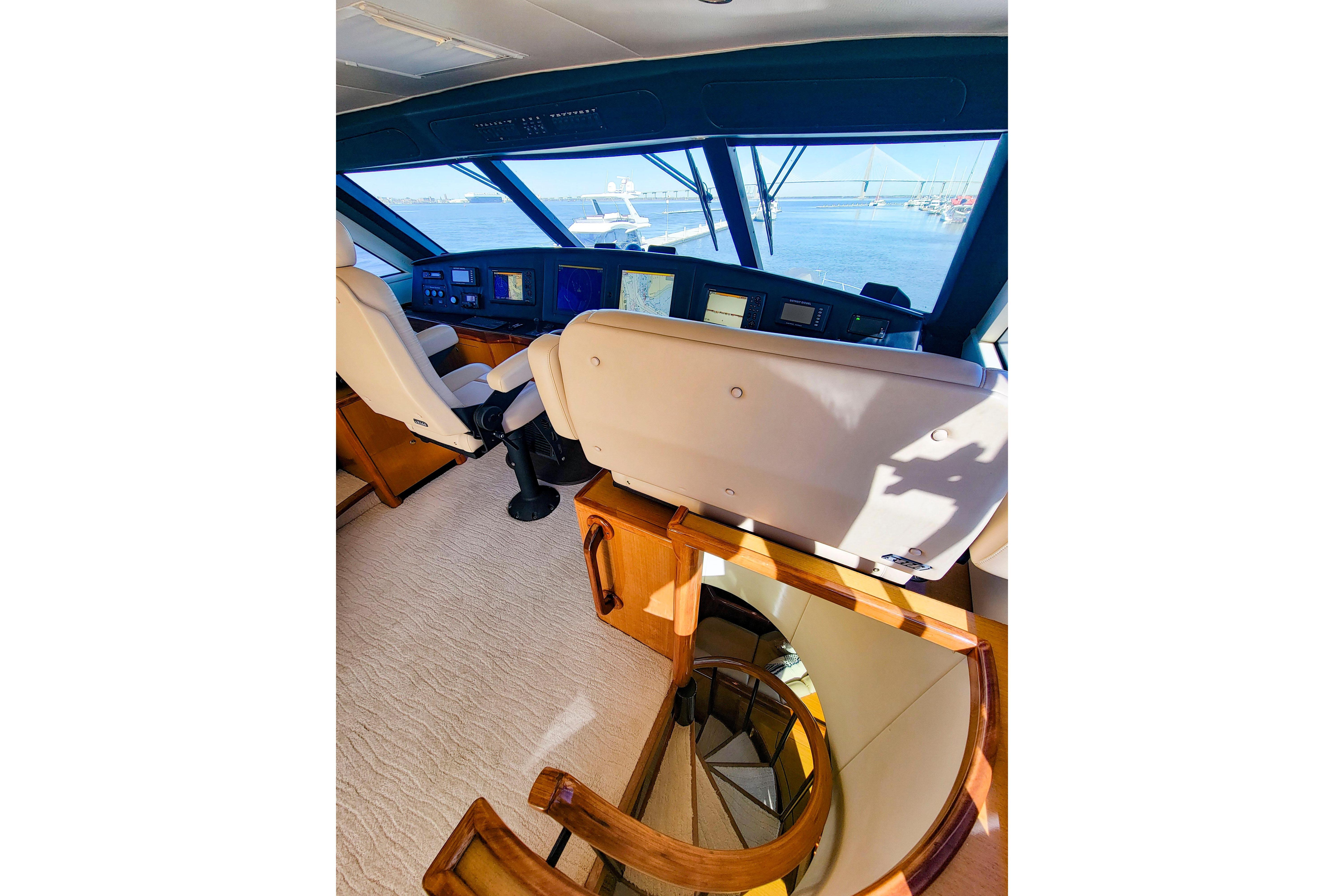 Interior view of 2002 Viking 65 Enclosed Bridge yacht helm with navigation screens.