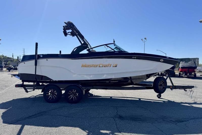 2026 MasterCraft XT22 boat on trailer, sleek design, black and white color scheme.