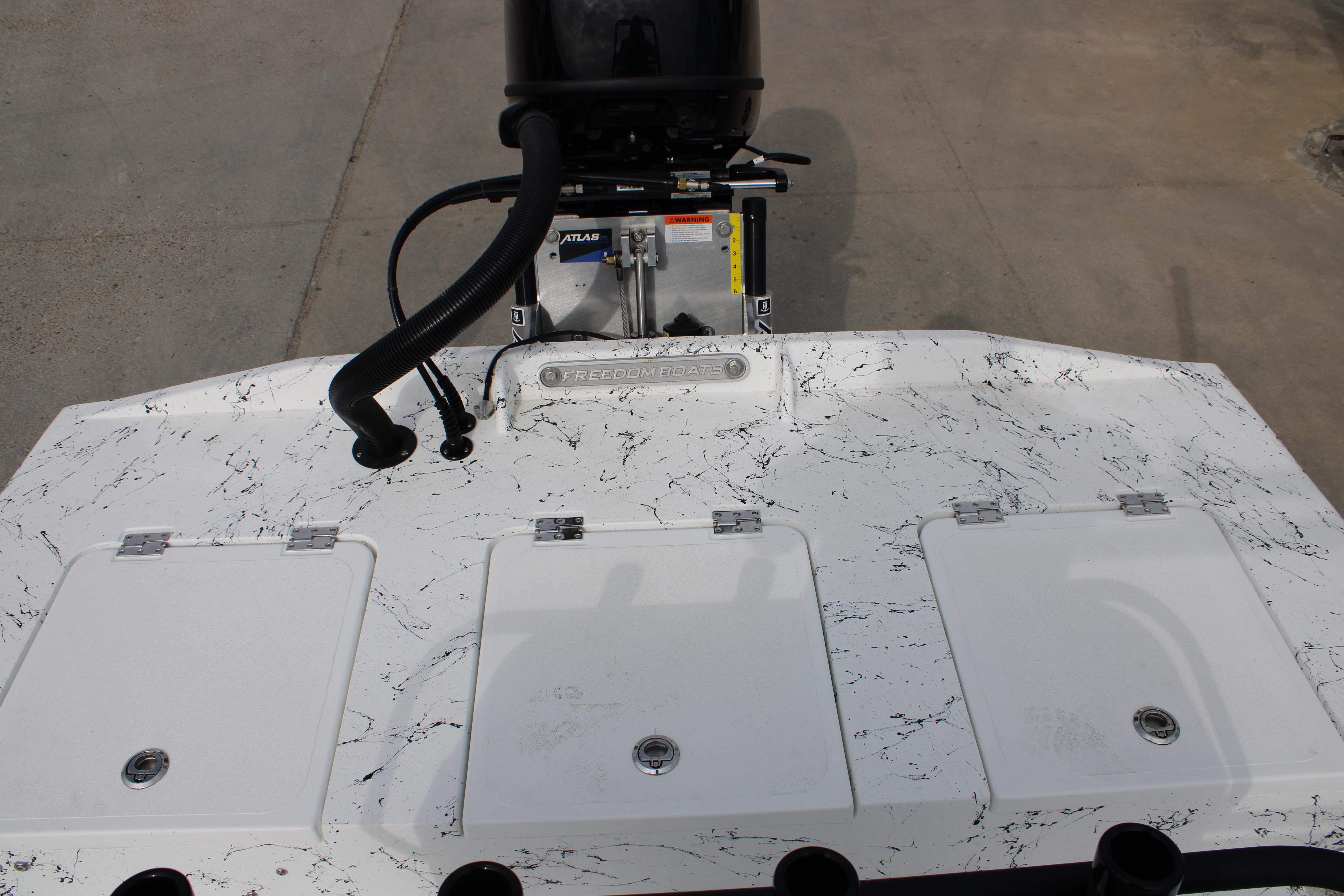 2026 Freedom Boats 19 PATRIOT with marbled deck and motor, showcasing storage compartments.