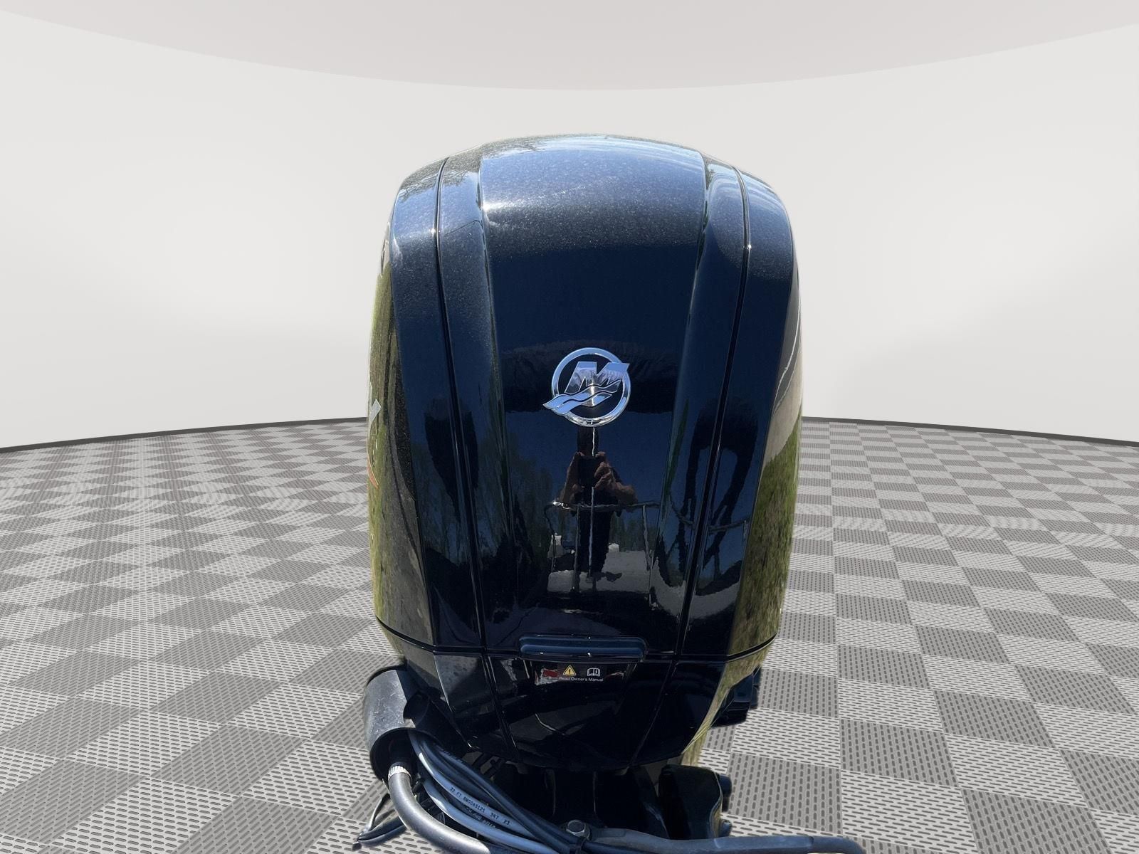 A black outboard motor with a silver logo on a checkered floor.